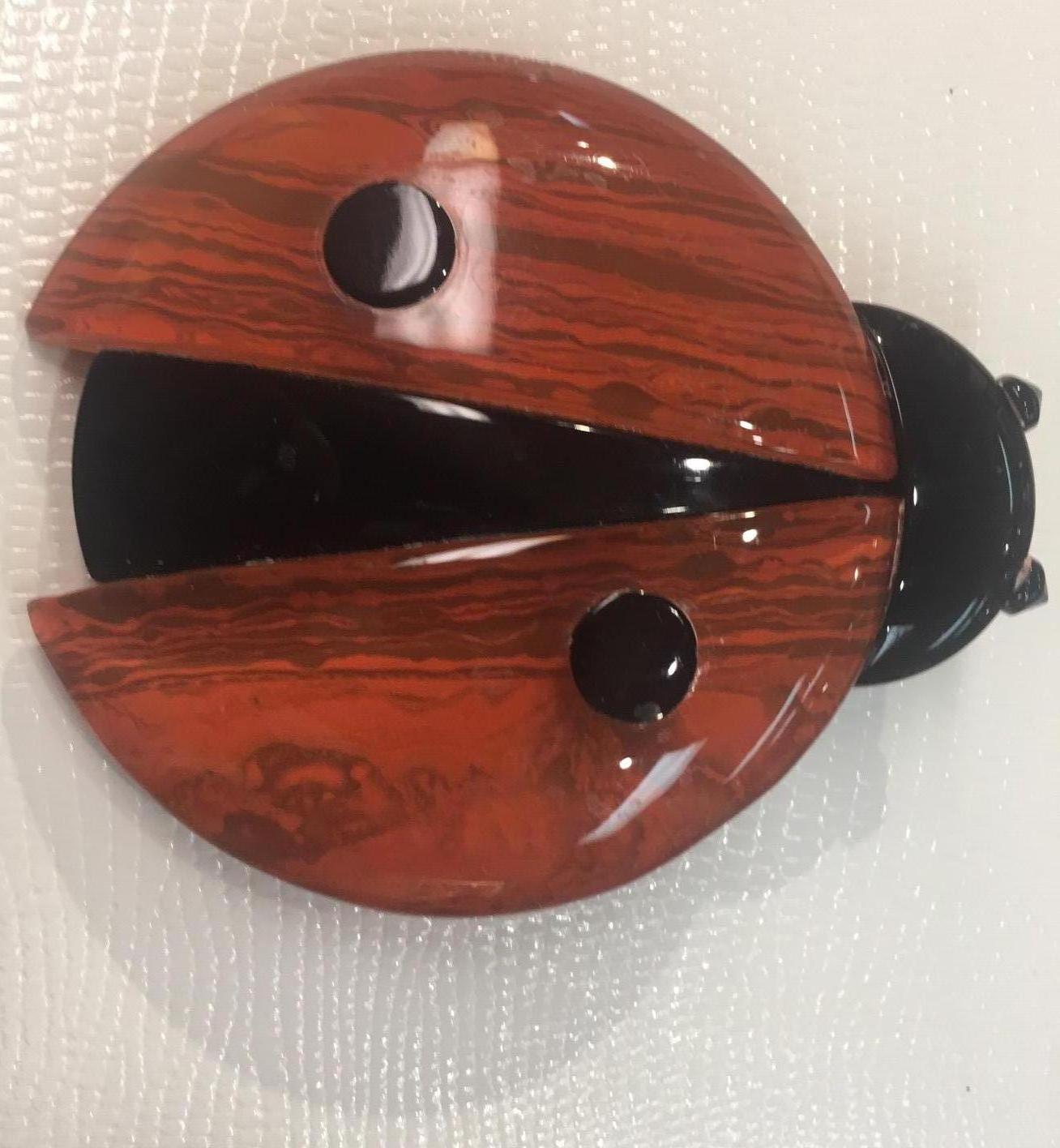 Fabulous Ladybird/Ladybug brooch pin by Lea Stein, Paris boosts a rich, vibrant shiny orange with contrasting black spots, one each side. The head, eyes and body are shiny black. The wings are in an orange with a subtle pattern like on watermarked