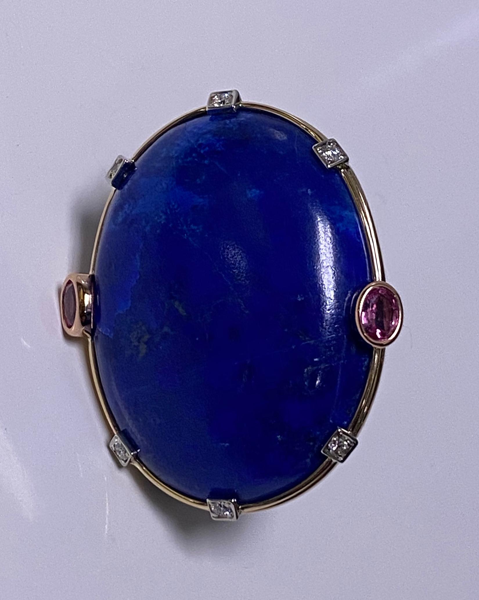 Large Lapis Lazuli Sapphire Diamond Gold Ring. Custom hand made set with a large oval cabochon lapis lazuli gauging approximately 38.0 x 28.0 x 22.5 mm, flanked on either side with an oval faceted pink sapphire, approximately 0.75 ct each,  total