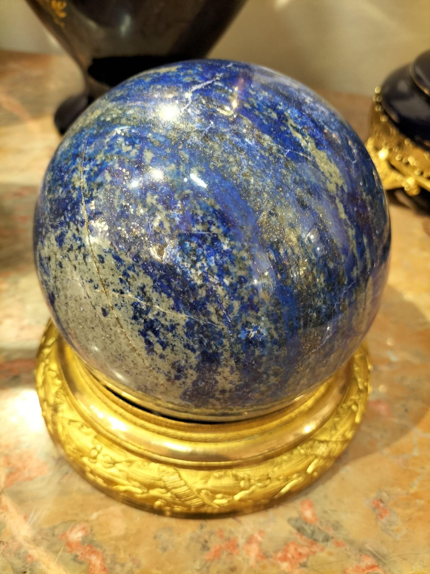 Siamo lieti di presentarti questa incredibile sfera lucida di Lapislazzuli, una roccia metamorfica di colore blu intenso spesso utilizzata in gioielleria e nella decorazione. 

La sfera mostra un vibrante mix di sfumature blu, intervallate da