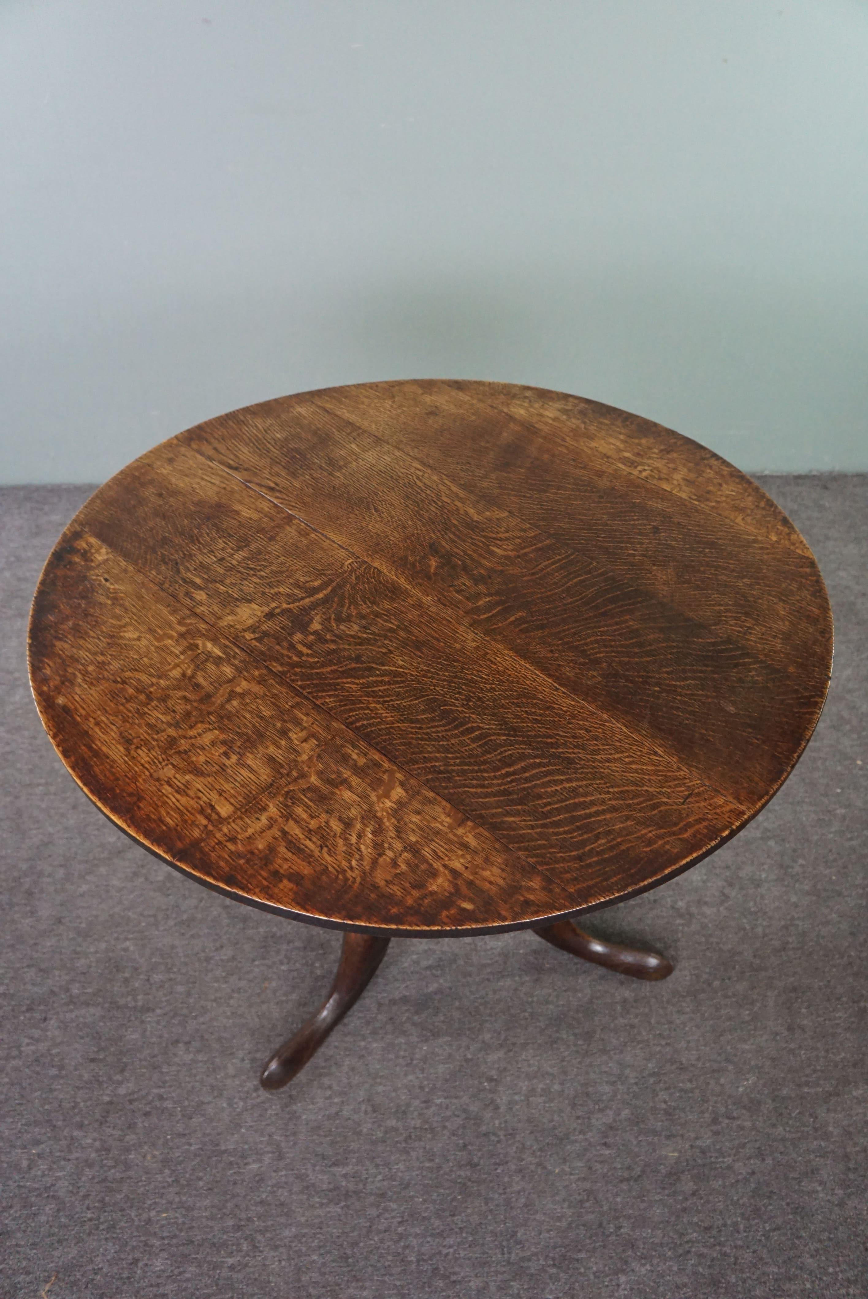 Offered is this beautifully stunning antique English tilt-top table from the 18th century. This gorgeous English tilt-top table is in good and proper condition. Due to its folding mechanism, it is easy to fold up and set aside if extra space is