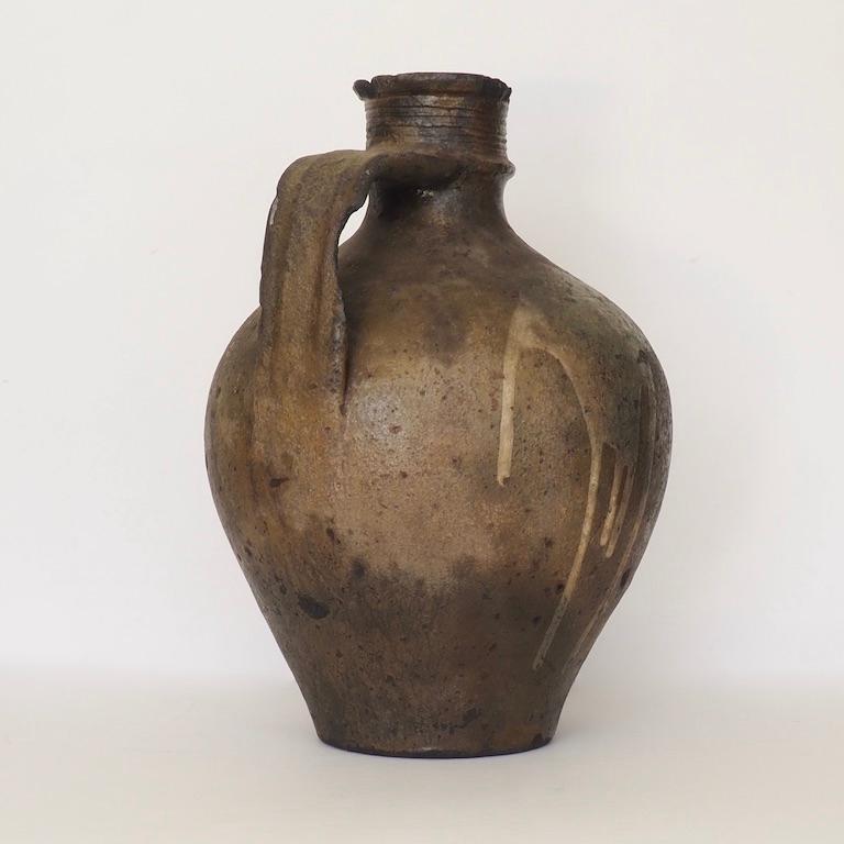 A large antique Portuguese stoneware jug with primitive slip decoration. Late 18th century. Jugs such as these were used throughout Iberia for water, oil and wine and found their way to the Americas where they held imported goods from Europe.