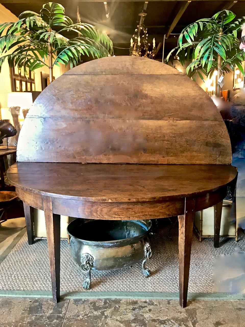 This is an usual and exceptional late 18th century. French Provincial oak demilune fold-over dining table that measures a full 69