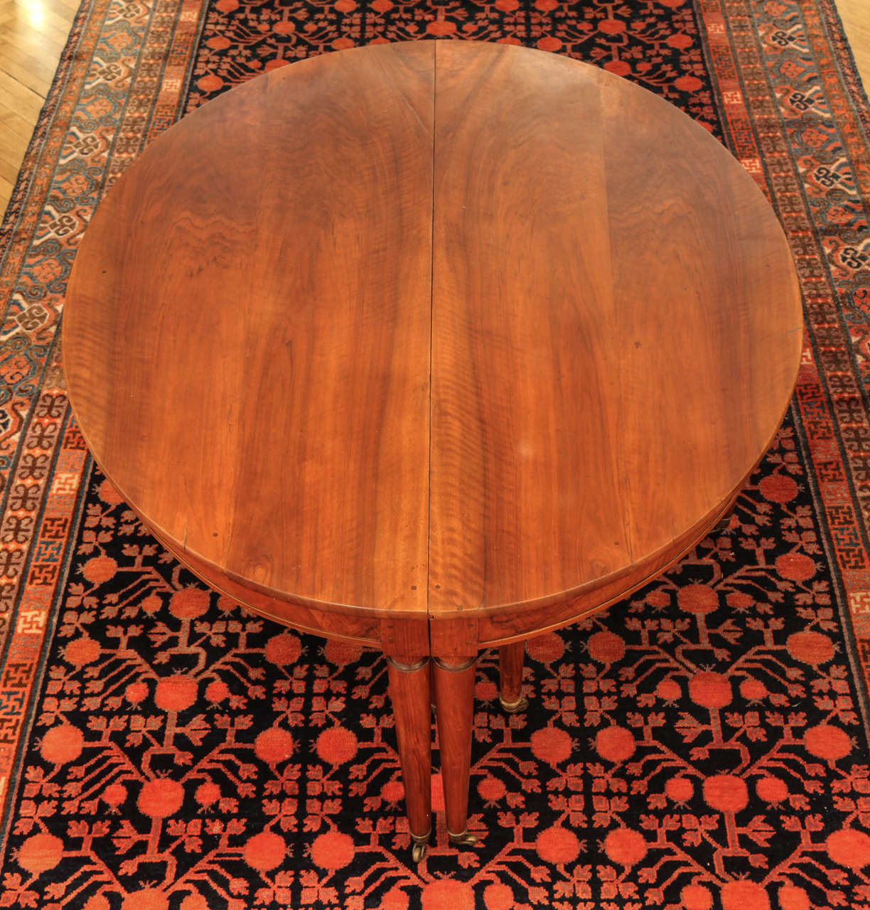 A large late 18th century, French oval extending walnut dining table with paneled frieze and five extensions, legs ending in capes and casters.
Measurements:

Height cm 74.
Width cm 170.
Depth cm 136 + 5x cm 60 Leaves; fully extended cm 436.