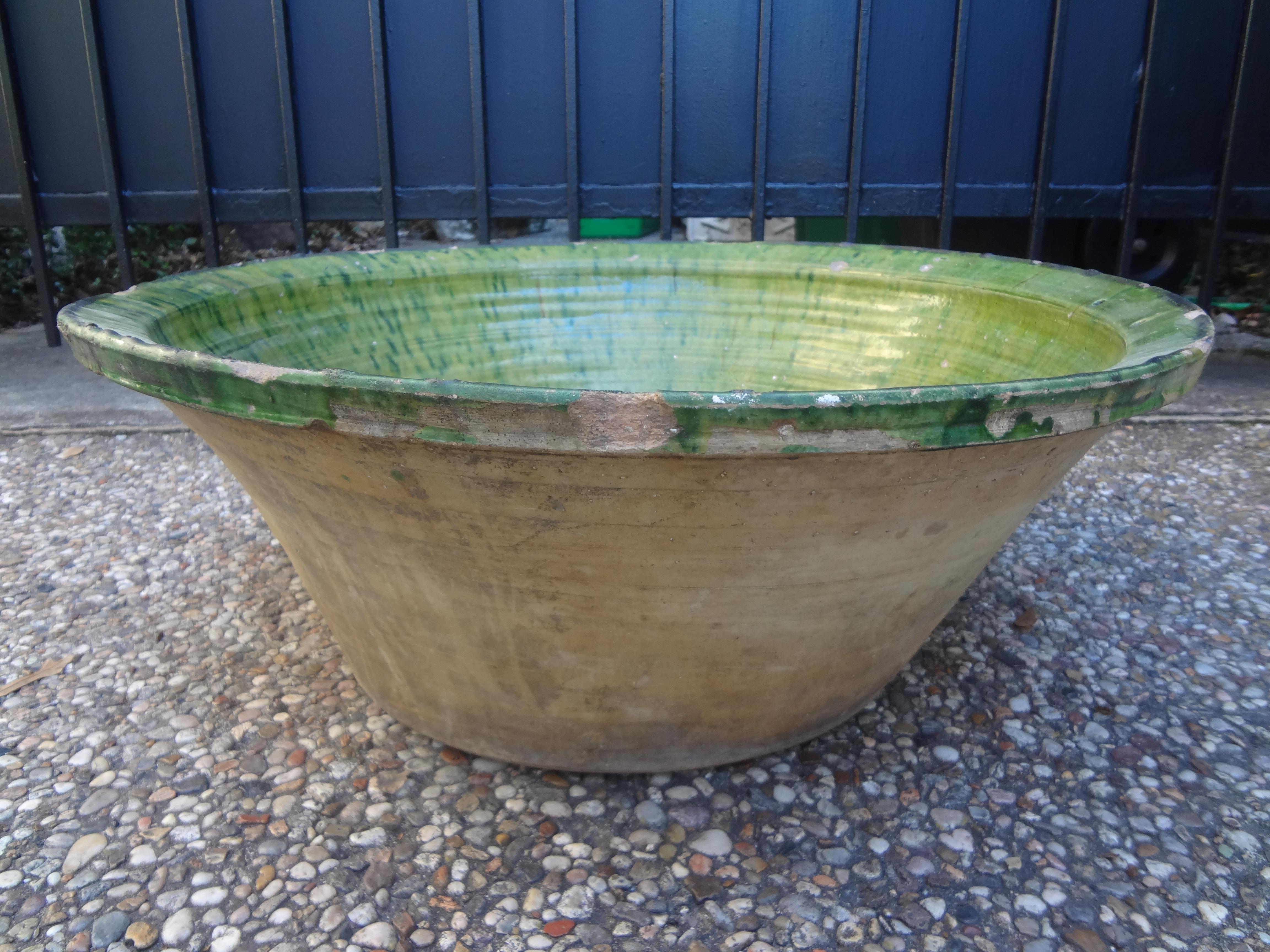Large late 18th early 19th century rustic French pancheon or dough bowl. This antique French dough bowl has a beautiful green glazed interior and an unglazed terra cotta exterior.
French pancheons were versatile terracotta bowls for kitchen use