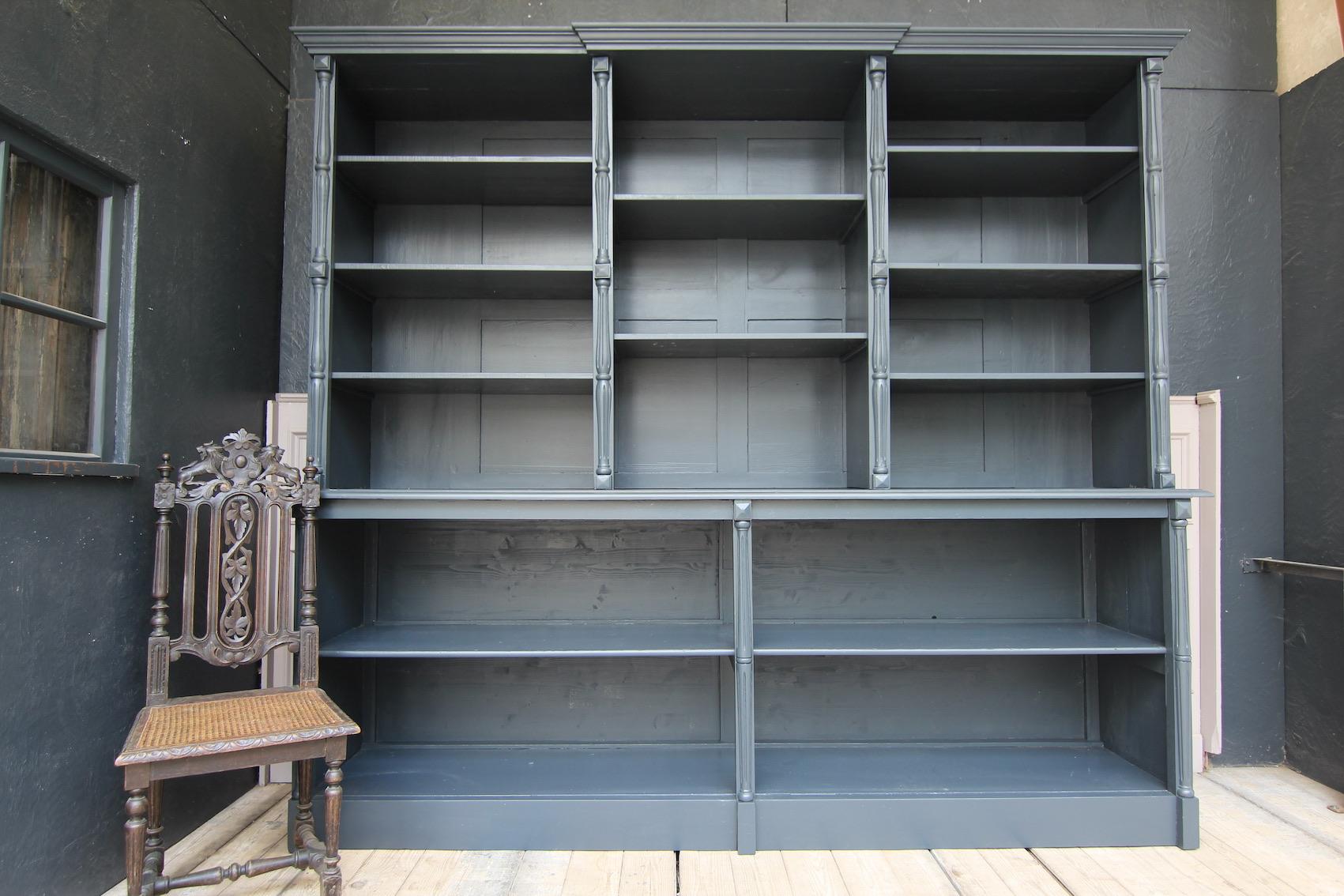 Large French shop cabinet or bookcase from an old shop fitting from around 1900. Made of solid pitch pine, newly painted in the color anthracite.

Consisting of 2 parts, the open lower part with continuous shelf and profiled cover plate, as well