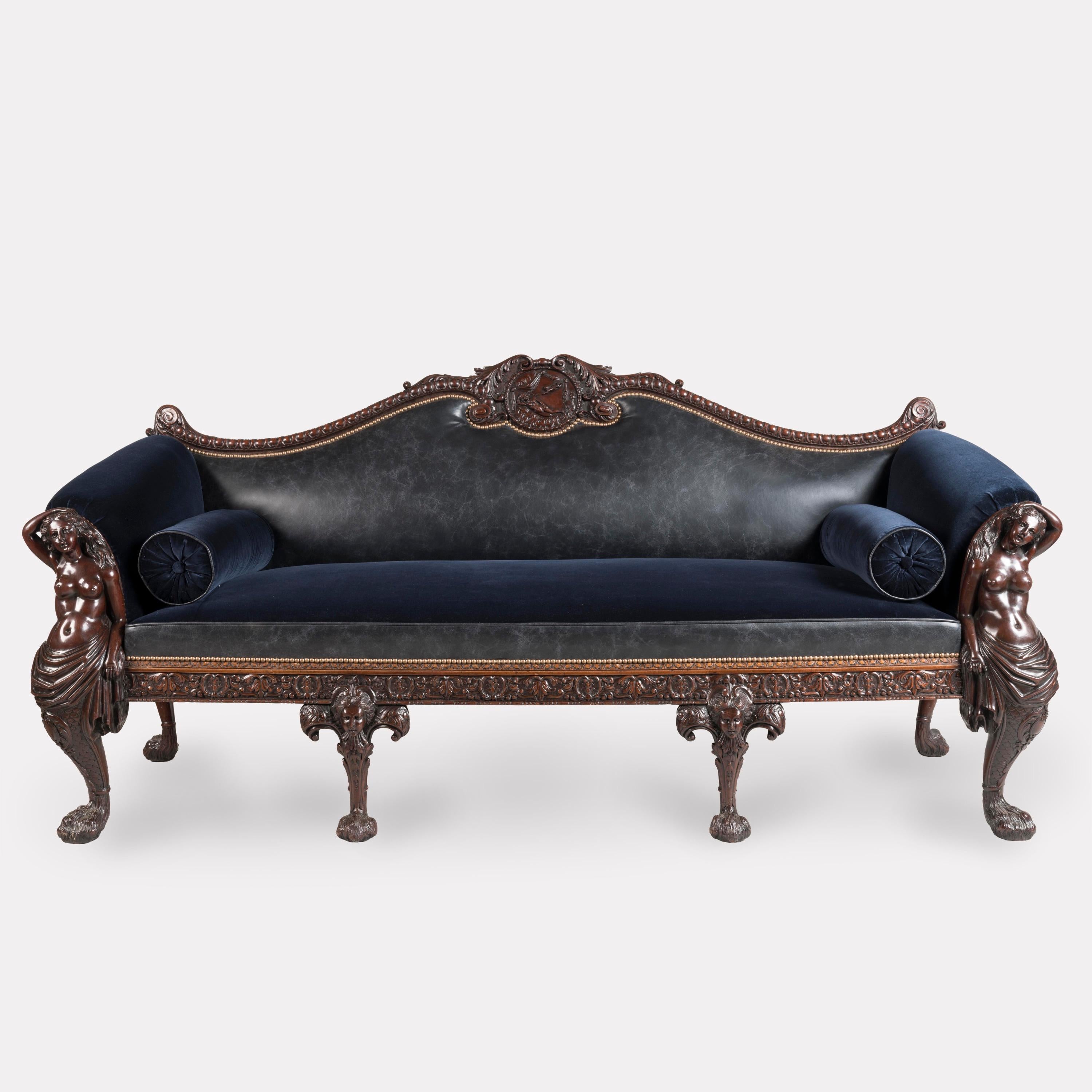 A Very Fine Settee After a Design by William Linnell 
Firmly Attributed to Maple & Company of London

The mahogany settee has the end arm supports carved with recumbent mermaids, terminating in Georgian style 'hairy paw feet', the centre legs carved