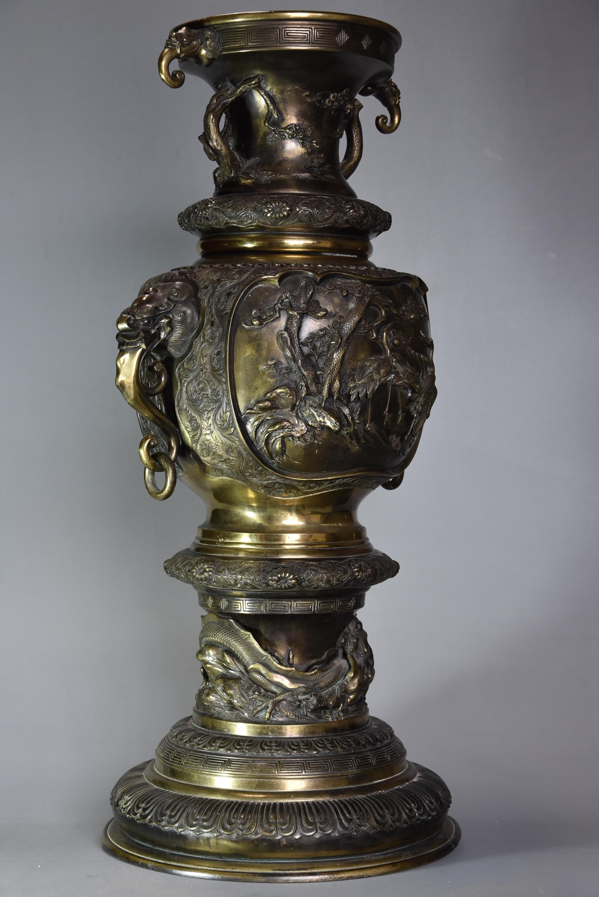 A large late 19th century Japanese Meiji period bronze vase of fine quality.

This bronze vase consists of a flared rim with geometric decoration to the edge with elephant head decoration.

This leads down to fine relief landscape scenes of