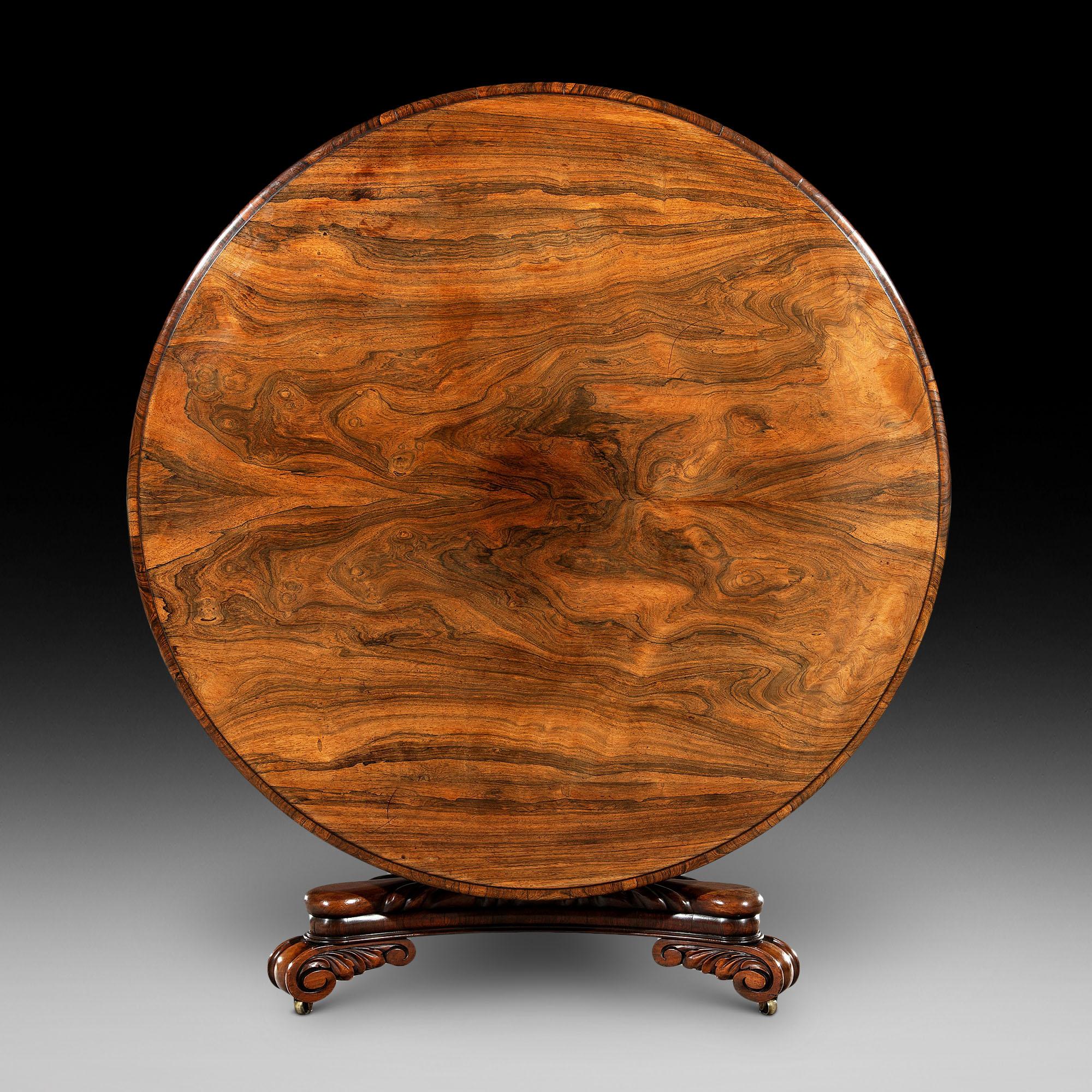 Large George IV Late Regency period eight-seat circular rosewood dining table the circular top is made on a mahogany base with bookmatched Brazilian rosewood veneers and a moulded edge above a concave cushion moulded cross banded frieze. The