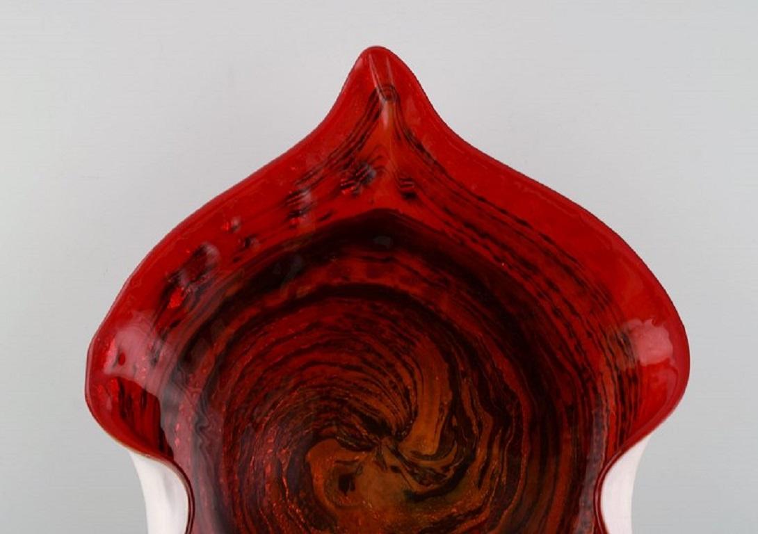 Large leaf-shaped Murano bowl in mouth-blown art glass with wavy edges. 
Red shades. Italian design, 1960s.
Measures: 28.5 x 8.5 cm
In excellent condition.