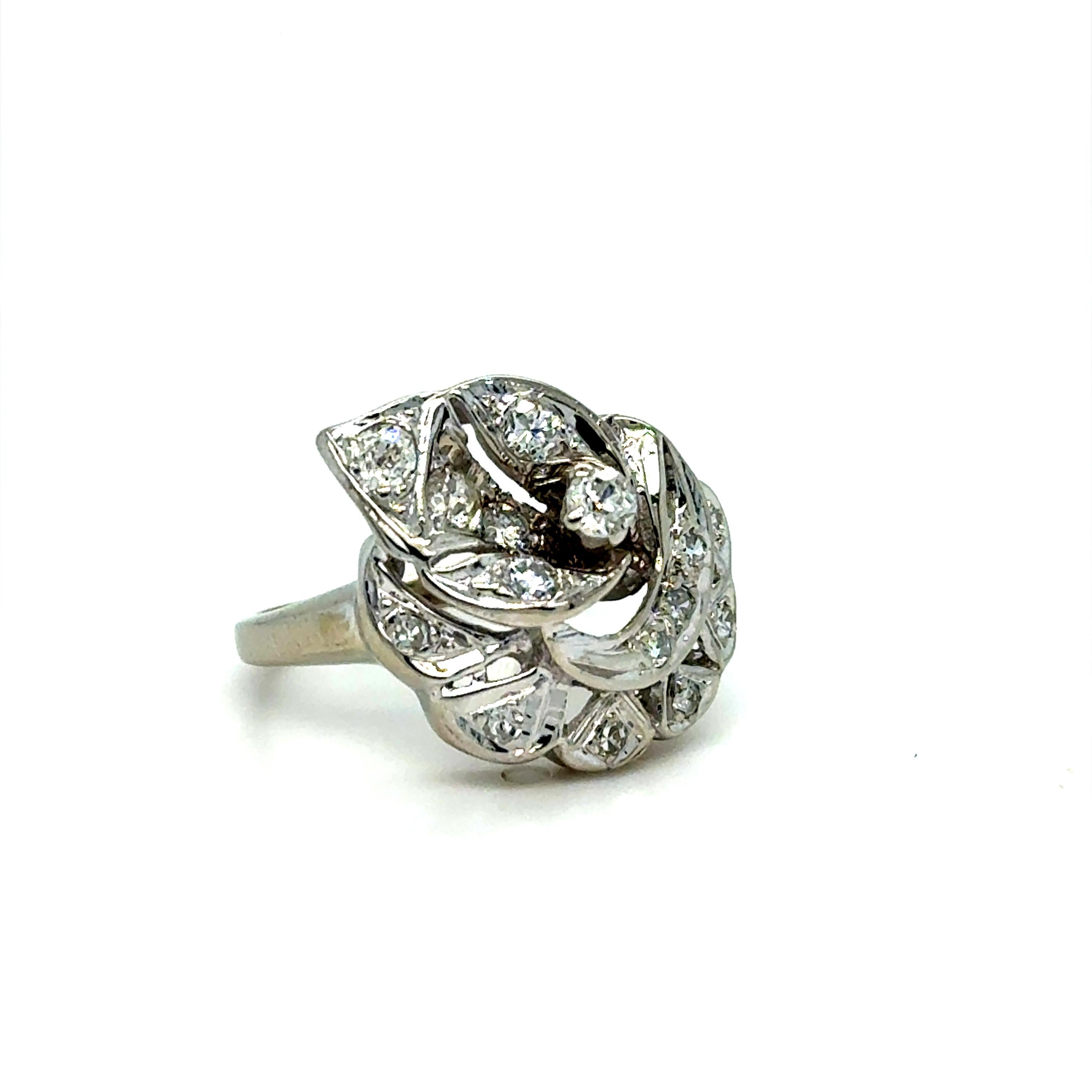 L'eleganza fiorisce in questo incantevole anello vintage. Realizzato in oro bianco 14 carati, l'anello presenta uno splendido gruppo di diamanti taglio brillante disposti in un abbagliante motivo floreale, incastonato in una grande foglia