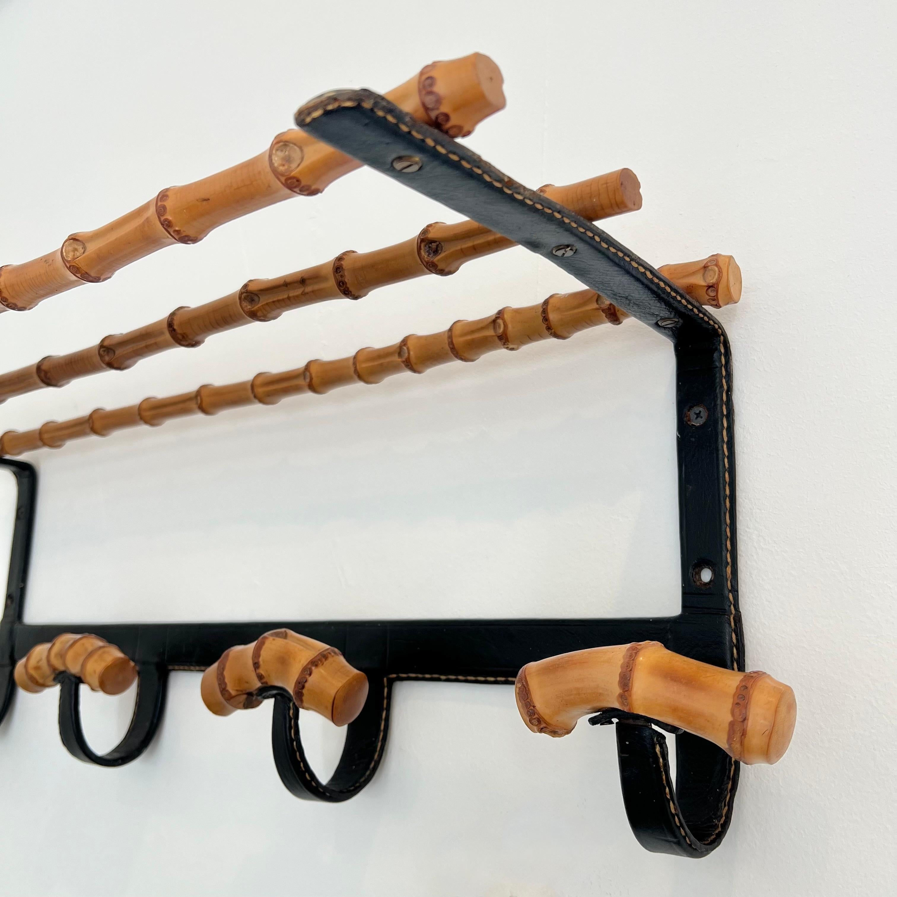 Uno splendido appendiabiti del designer francese Jacques Adnet. La struttura in ferro nero è completamente rivestita in pelle nera, con le cuciture a contrasto tipiche di Adnet. Ogni gancio è inoltre avvolto in pelle con un unico pezzo di bambù