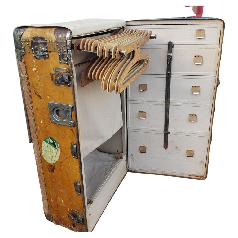 An impressive Large wardrobe steamer trunk travel case from the early 20th c.  The interior features 5 drawers, 11 full hangers, 1 cloth screen and a lined storage box. While designed for travel for sea travel back then, this piece is perfect for