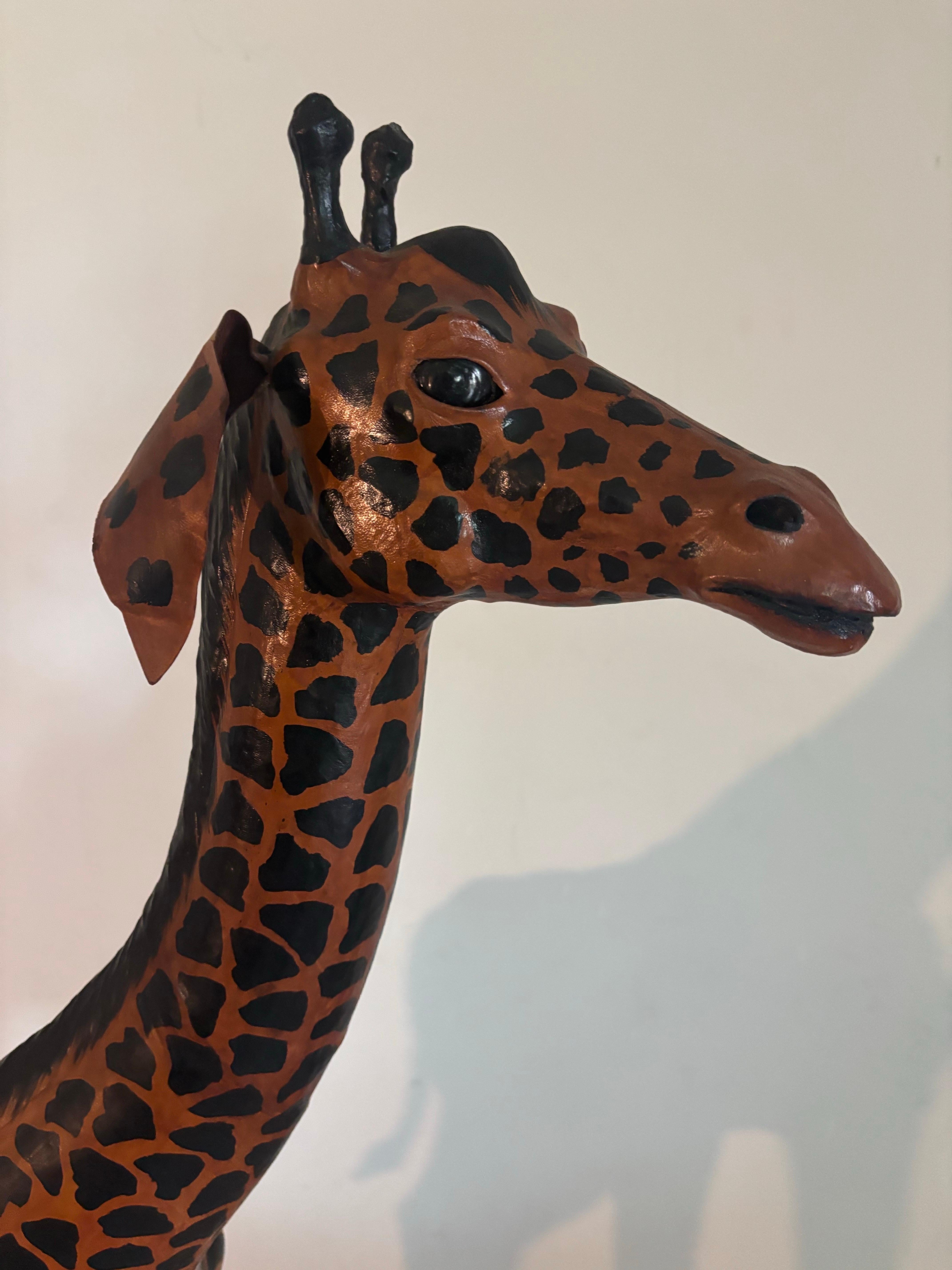 Grande scultura di giraffa in pelle lavorata a mano. Con i suoi 51 pollici di altezza, è un pezzo forte per qualsiasi stanza. La scultura è rivestita in pelle e dipinta a mano. 

Dettagli eccezionali.