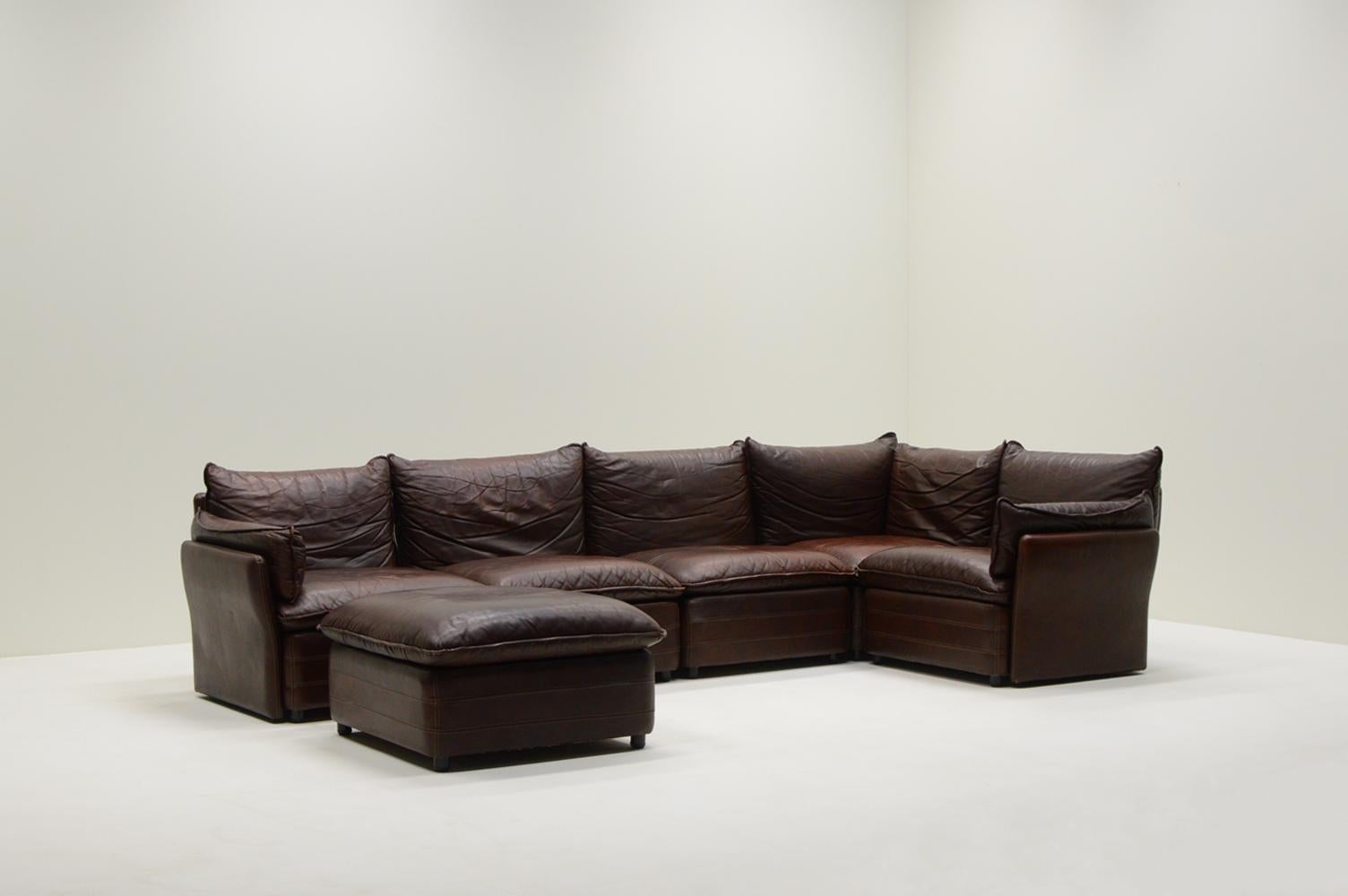 Sofá modular grande de cuero, Alemania, años 70. Diseñador desafortunadamente desconocido. 6 piezas de cuero de color marrón oscuro con toques de rojo oscuro. 1 rinconera, 2 sillas, 2 sillones con reposabrazos y 1 otomana. Colócalos como quieras. El