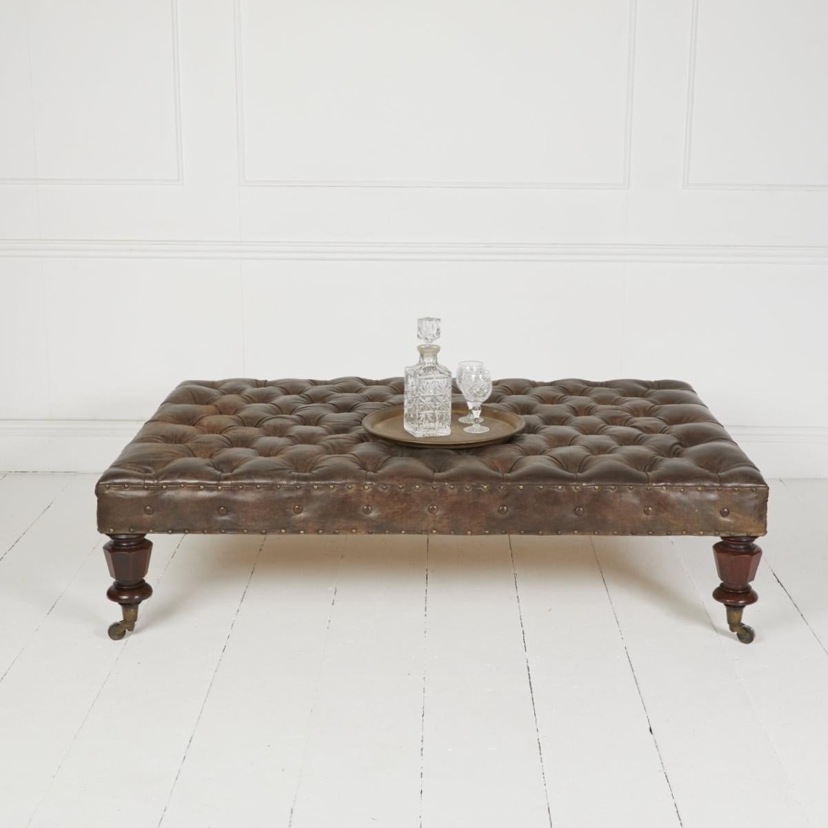 Traditionell gepolsterter Hocker in Kutschenbauweise, bezogen mit handantiquiertem italienischem Leder. Steht auf antiken englischen Mahagoni-Beinen und historischen Rollen.

Abmessungen: H 16″  B 59″ T 40″

Festlandzustellung FOC London