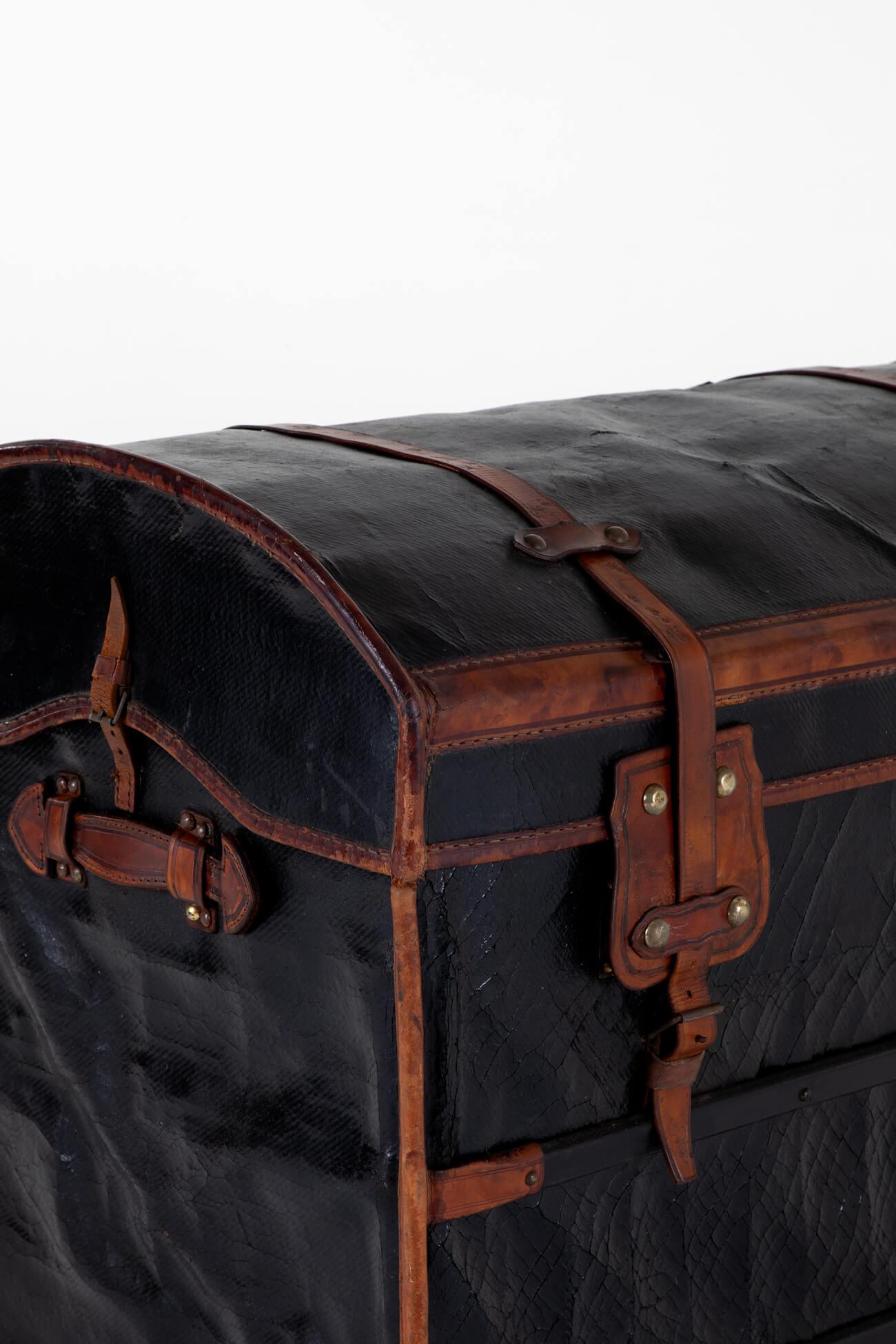 A wonderful late 19th-century leather steamer trunk.

The trunk is made of canvas and has been leather-mounted around a wicker dome top. Two large buckles to the front of the trunk secure the lid coupled with a small buckle to either end. To the