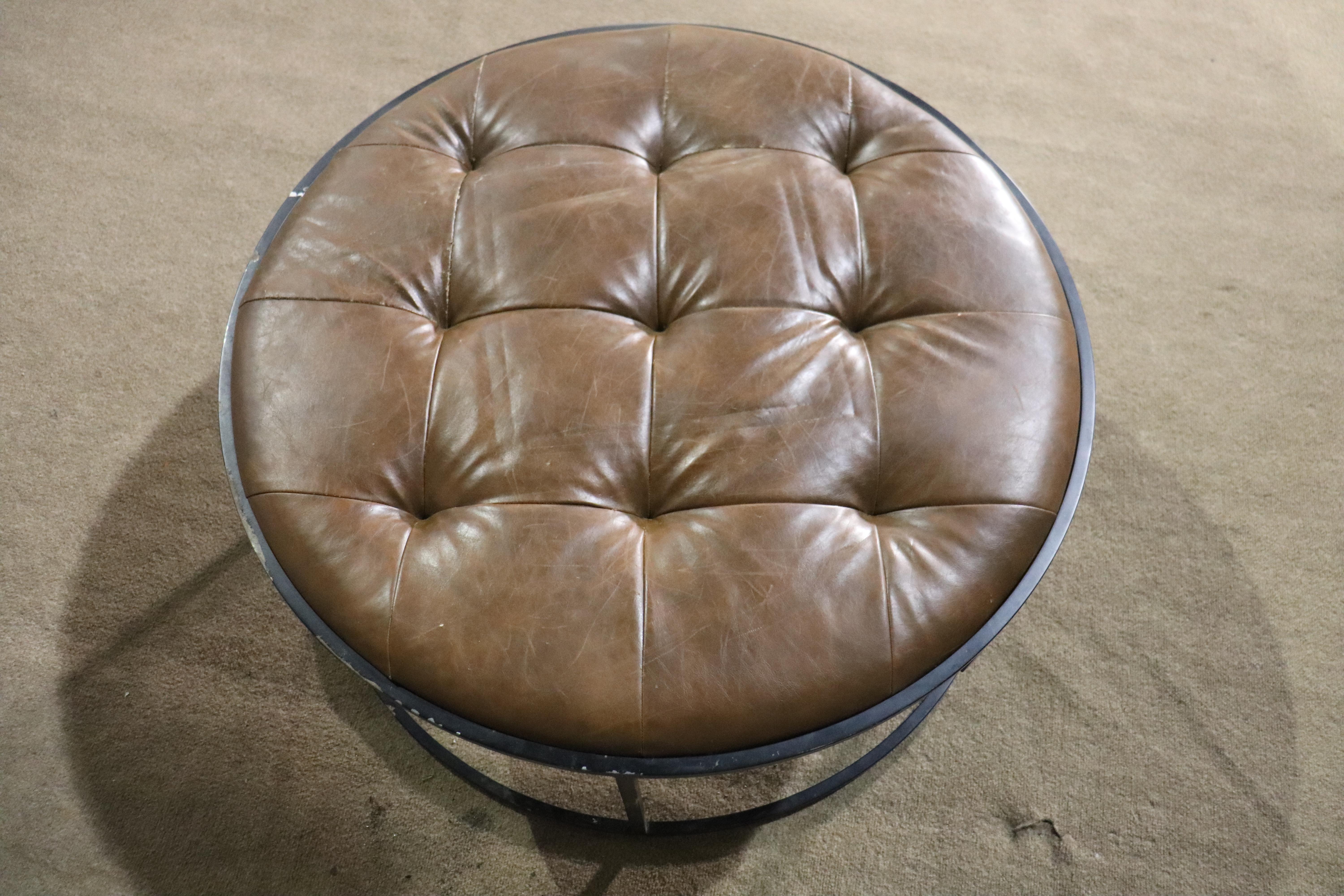 Large 3 foot wide ottoman with tufted leather top and strong iron base. Great age and patina throughout the leather. Can be used as a table. Made for the Millwork Holdings Company NYC.
Please confirm location NY or NJ