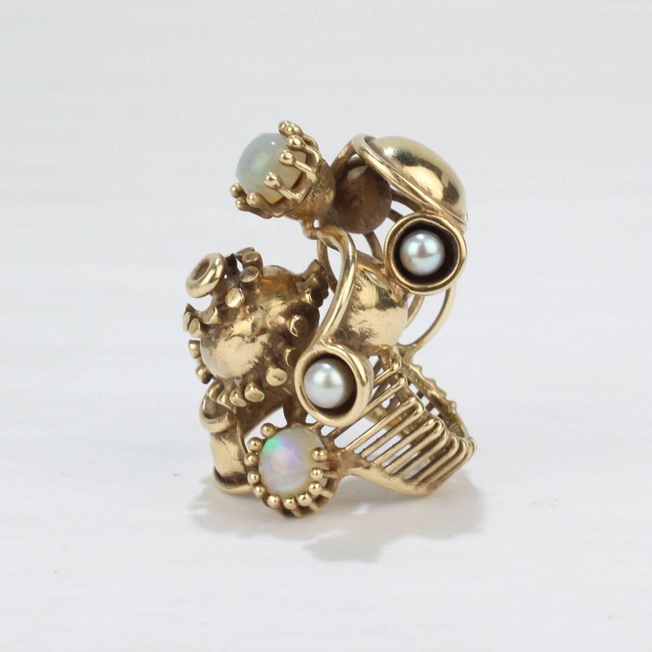 A wild Steam Punk 14 karat ring with pearls and opals by Lee Peck.

Simply a fun ring to wear in a impressively large size!

Lee Barnes Peck was a distinguished Professor of Metal & Jewelry at Northern Illinois for decades. His work is held in