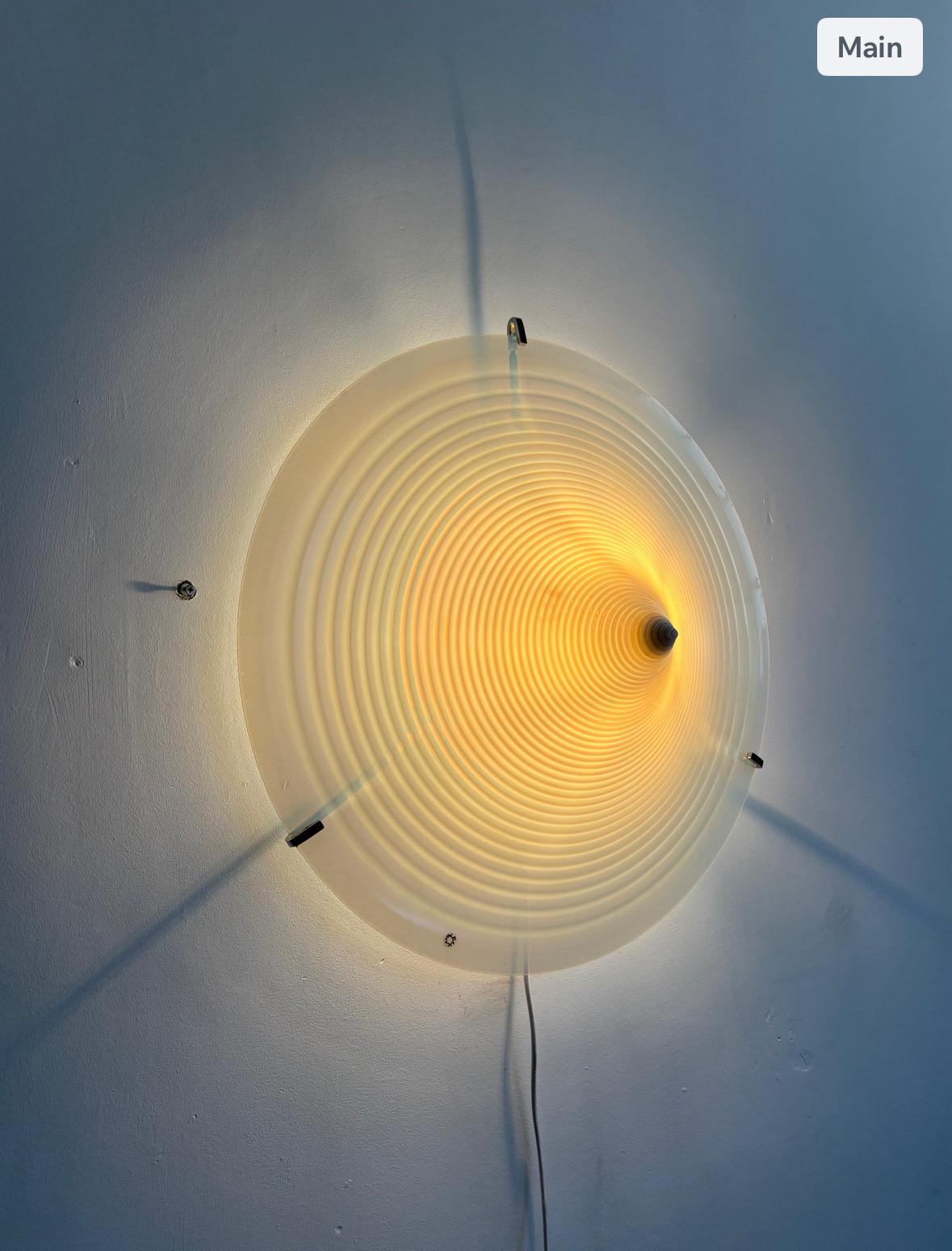 Este llamativo aplique o plafón de gran tamaño, fabricado por Leucos en la década de 1960, presenta un elegante difusor de cristal matizado en blanco y azul que emana un suave resplandor atmosférico. Los tonos sutilmente mezclados crean un efecto