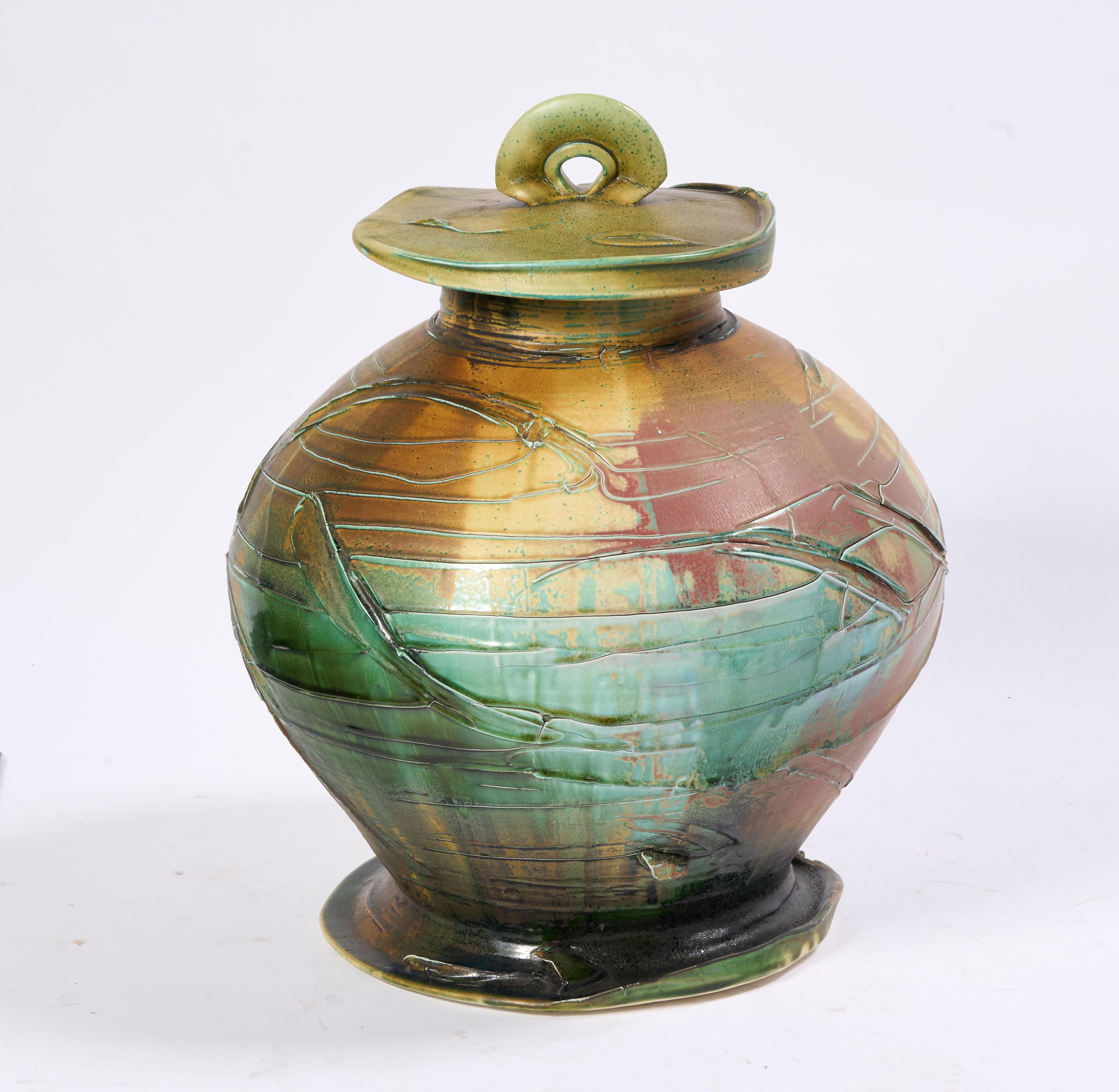 A gorgeous and very large lidded pottery vessel by noted ceramicist Chris Staley. 

Beautiful palette of greens, pinks, blues, goldenrod, & chartreuse. Fantastic texture to the piece with a slight 