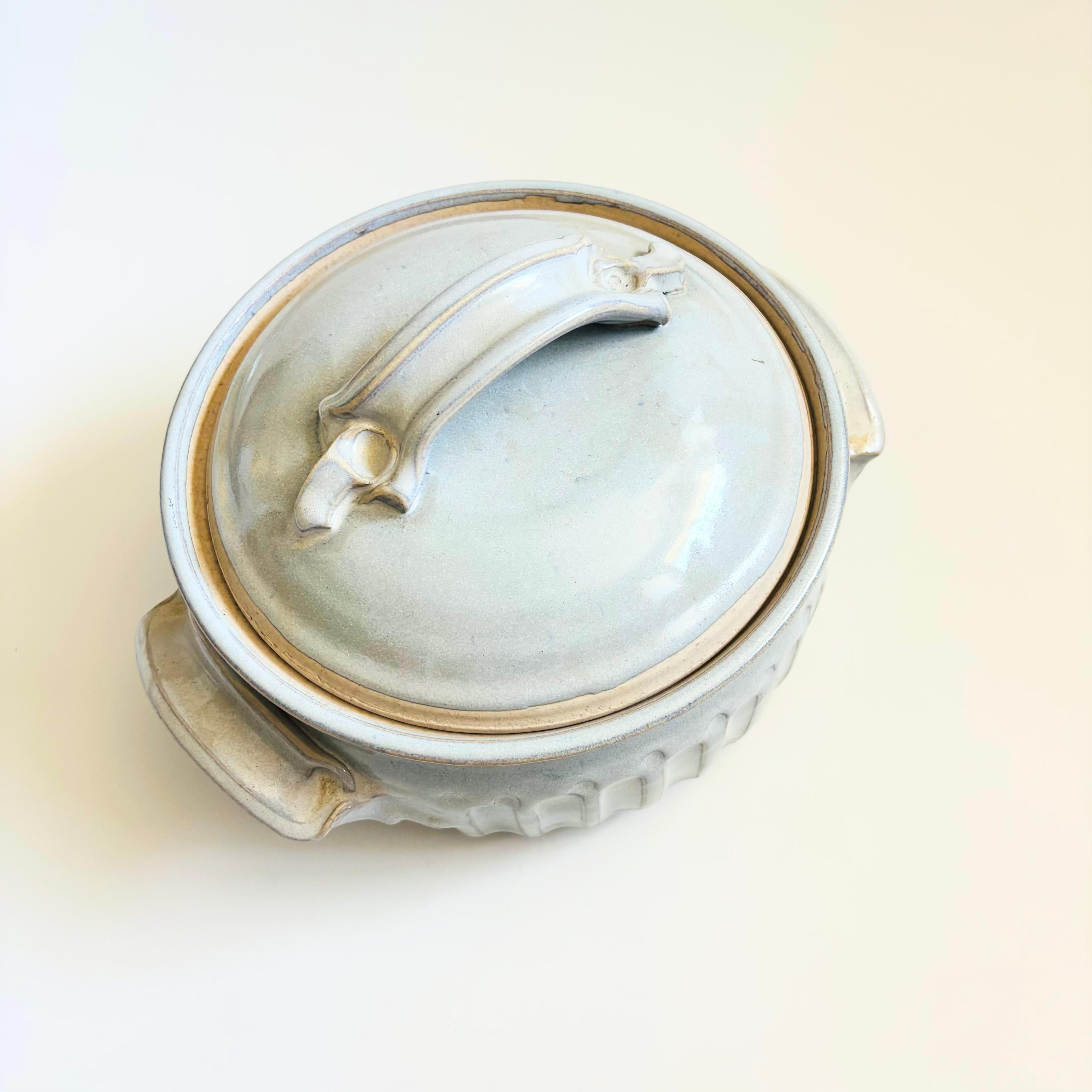 Un beau grand bol de service vintage en poterie fait à la main avec couvercle. Glaçure gris pâle avec accents sculptés. Belle taille, parfaite pour servir une variété de plats. Signé sur la base par le fabricant.

