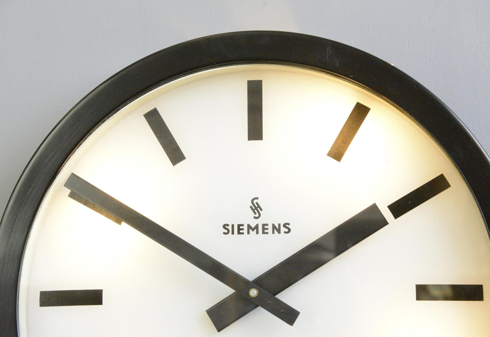 Large light up factory clock by Siemens, Circa 1960s

- Aluminium casing
- Glass face and dial
- Original hands
- New AA battery powered quartz motor
- Made by Siemens 
- German, 1960s
- Measures: 57cm wide x 8cm deep

Condition