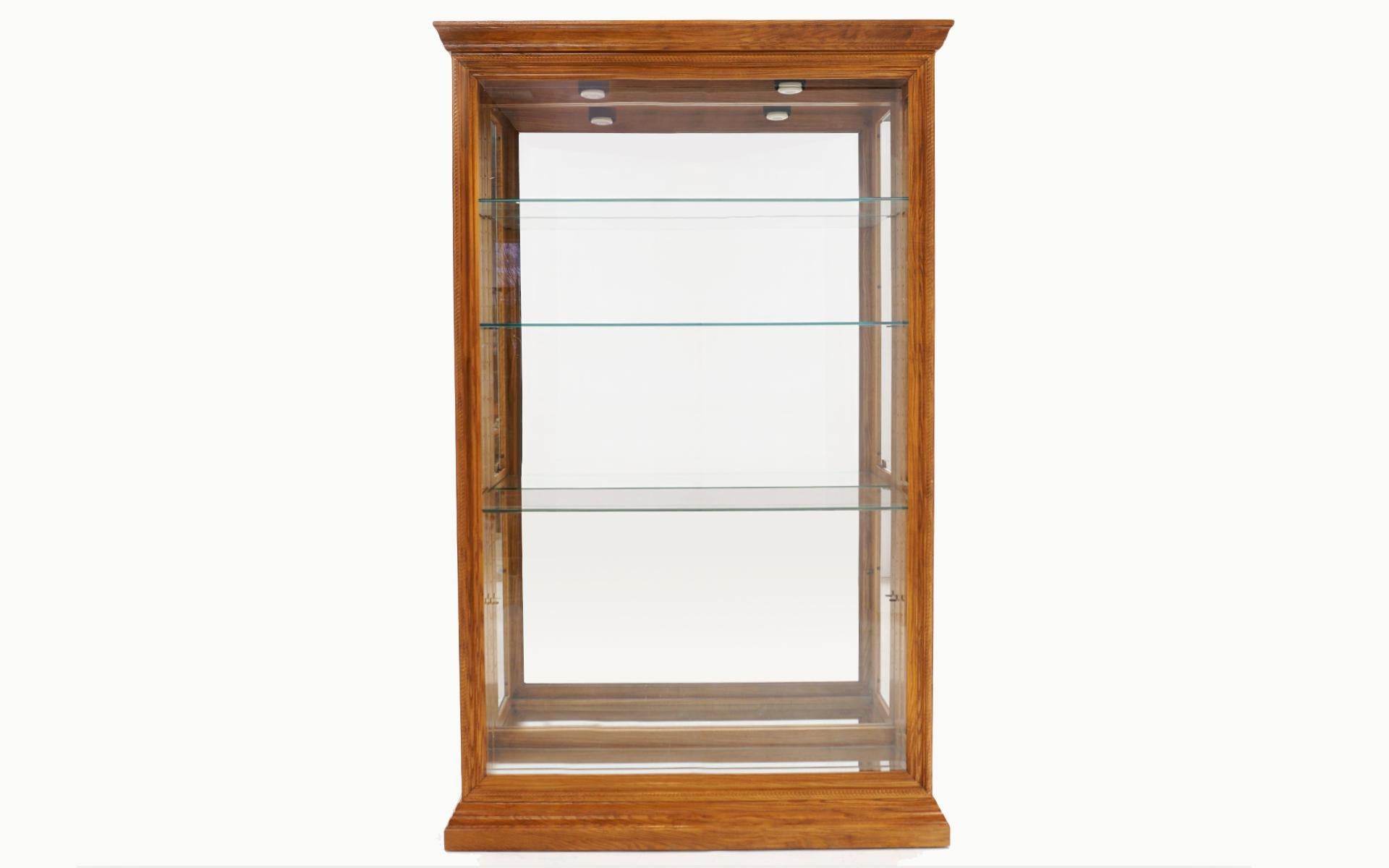 Walnut and glass lighted display / storage cabinet with five adjustable glass shelves (only three are shown in the photos). All parts are original. Access to the interior is through the side glass panels with the brass pulls. No chips or cracks to