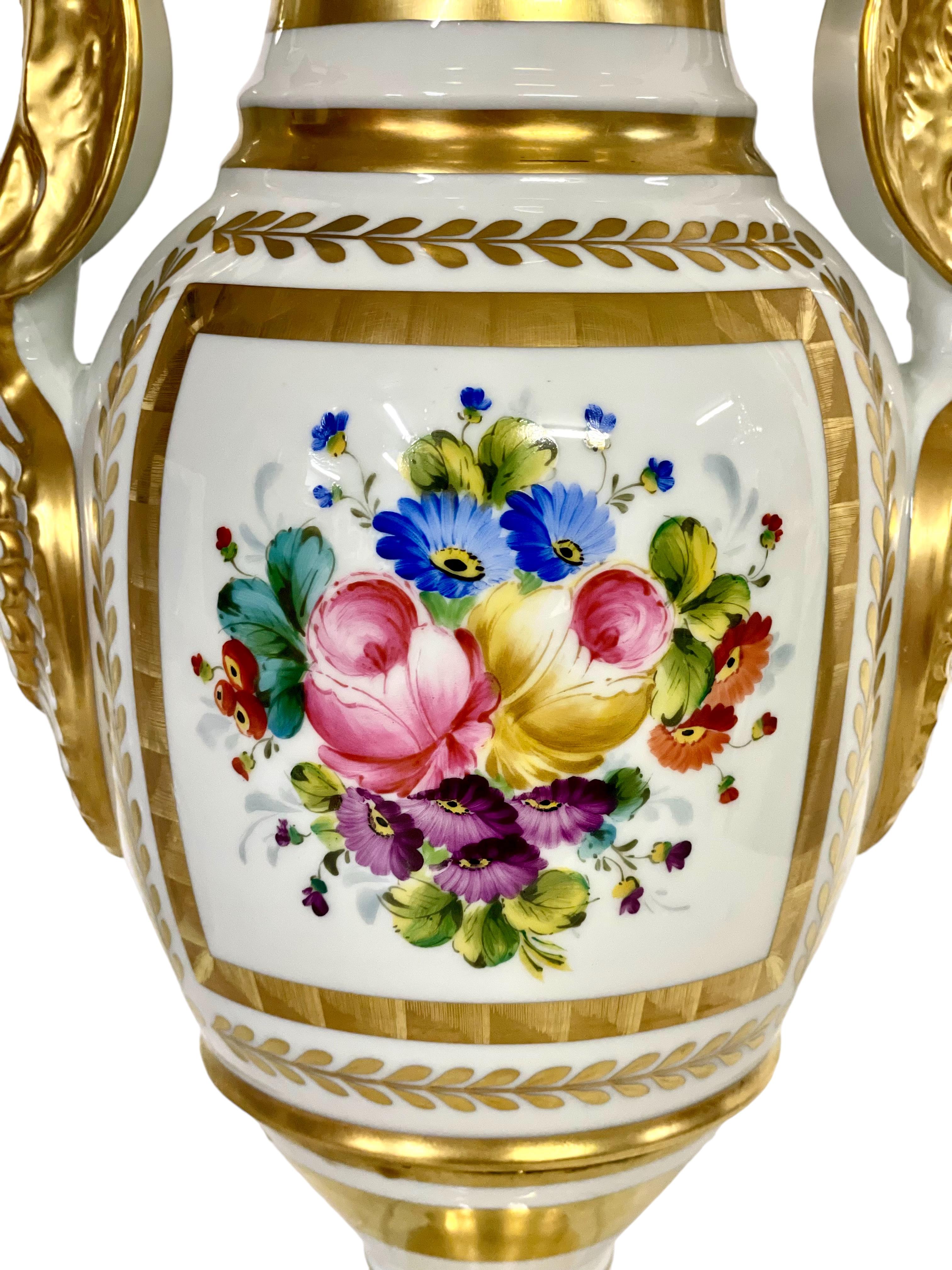 Gran jarrón de pedestal en forma de balaustre, de porcelana de Limoges pintada a mano, que data de mediados del siglo XX. Con una exquisita decoración de flores primaverales en vibrante policromía pintada por Réné Caire, un artesano de Limoges de