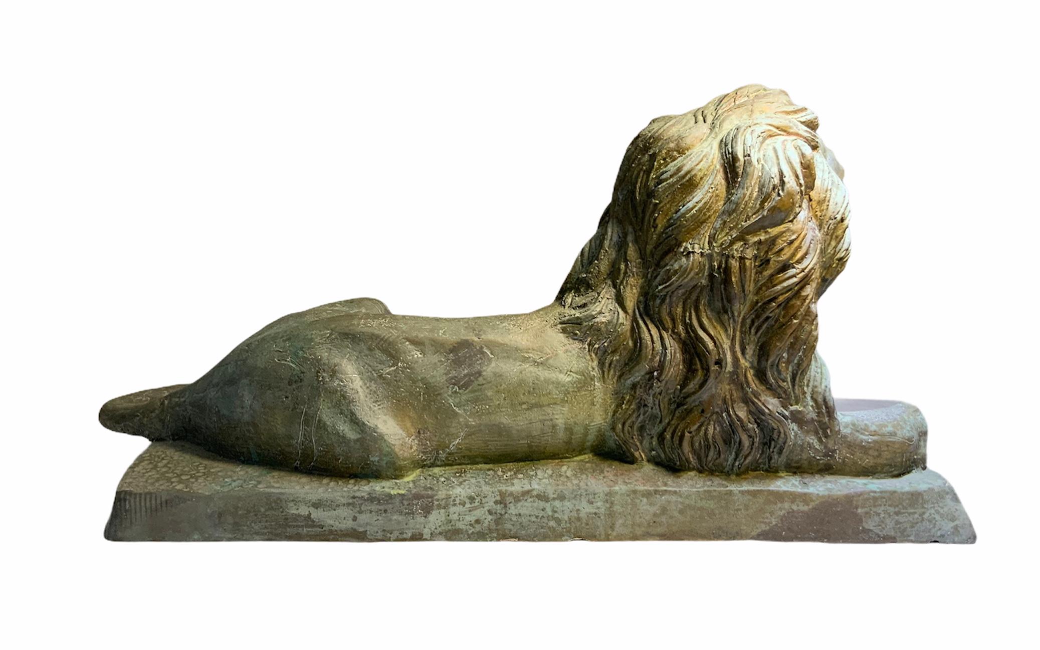 Il s'agit d'une grande sculpture en bronze de très bonne facture représentant un lion couché sur une base rectangulaire. Les détails de la sculpture de l'épaisse crinière, des pattes, de la queue, du nez et des yeux sont remarquables. Dans la