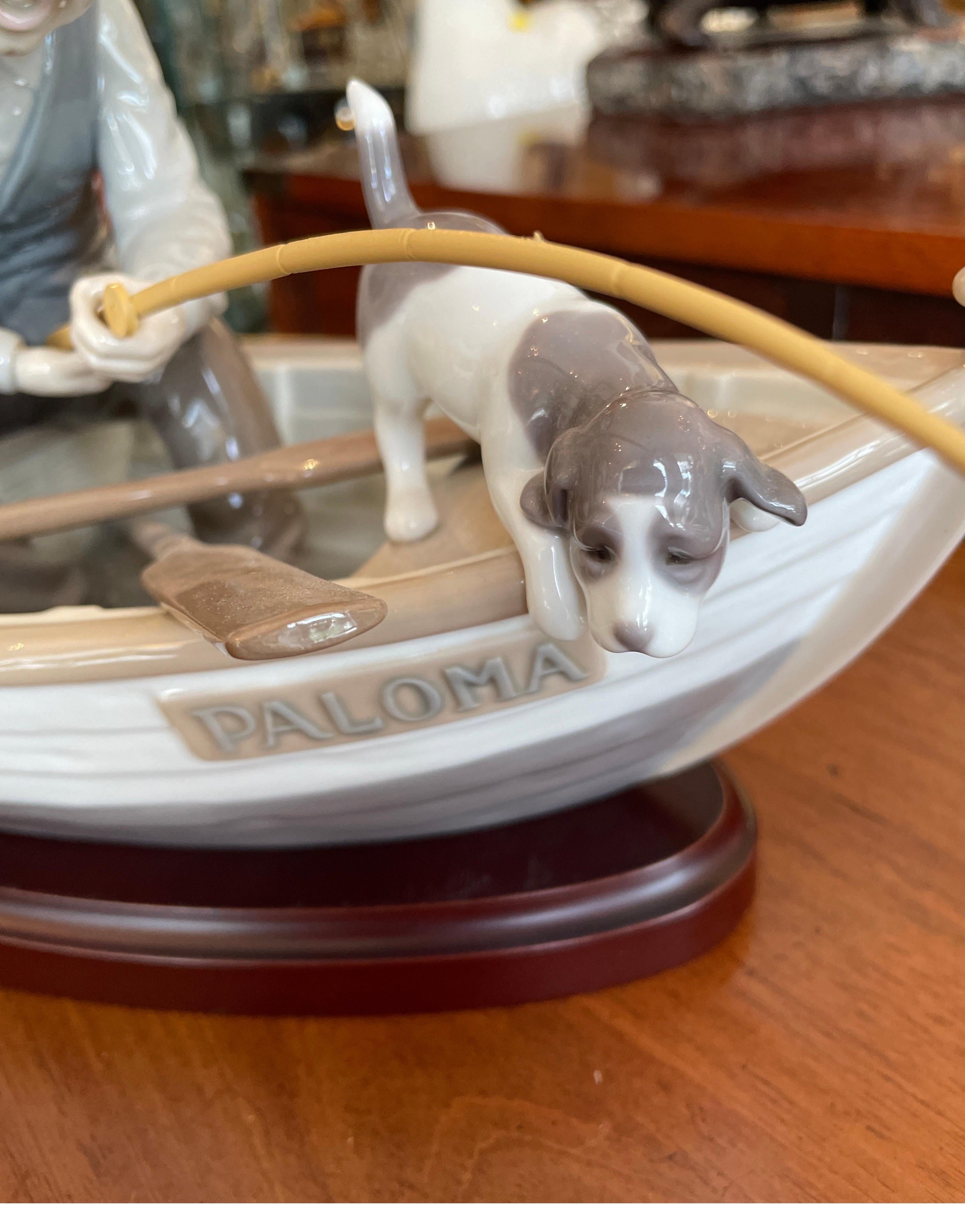 Very sweet Lladro figurine of a fishing boat with a young boy, dog and grandfather figure. A collector's piece. In excellent condition.