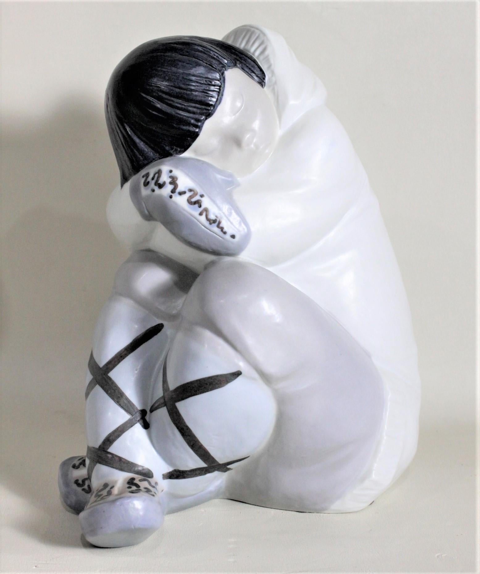 This very large hand painted porcelain figurine was made by the renowned Llladro company of Spain in circa 1985. The figurine depicts a young Inuit boy crouched with his head in his arms for a nap or contemplation. The hand painted details are done