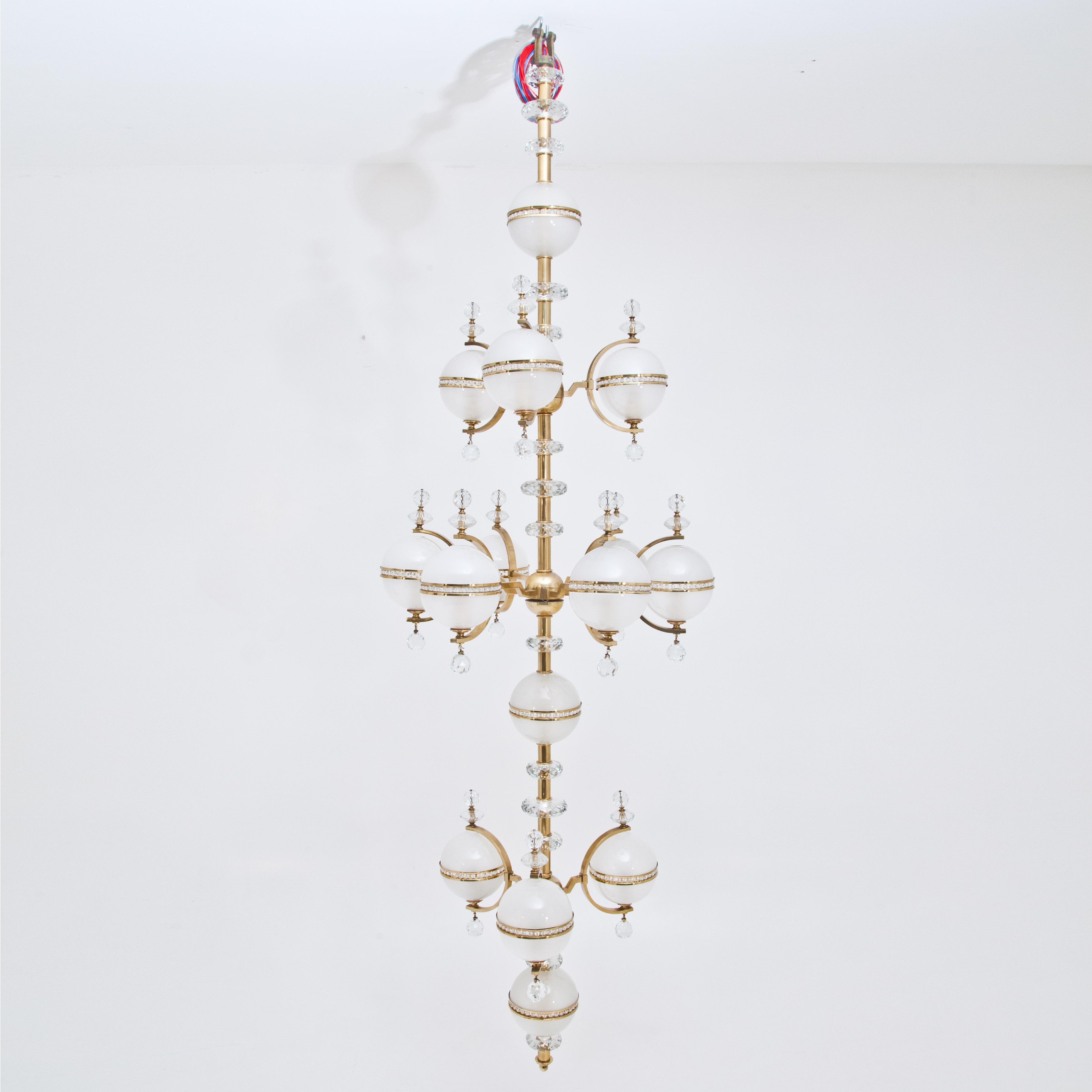 Large chandelier with cut crystal glass elements and a total of 15 spherical glass bodies of opal glass grouped around the central brass rod. Stamped Lobmeyr.