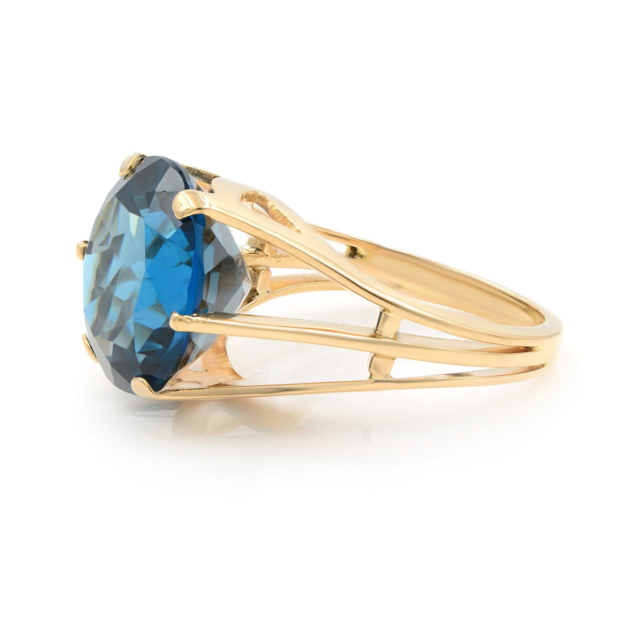 An enchanting gemstone, an elegantly fashioned faceted round London blue topaz, weighing 8.50 carats and suffused with a bright ocean hue, glistens and glow in this charming estate jewel. Rendered in gleaming rose gold and finished with an open