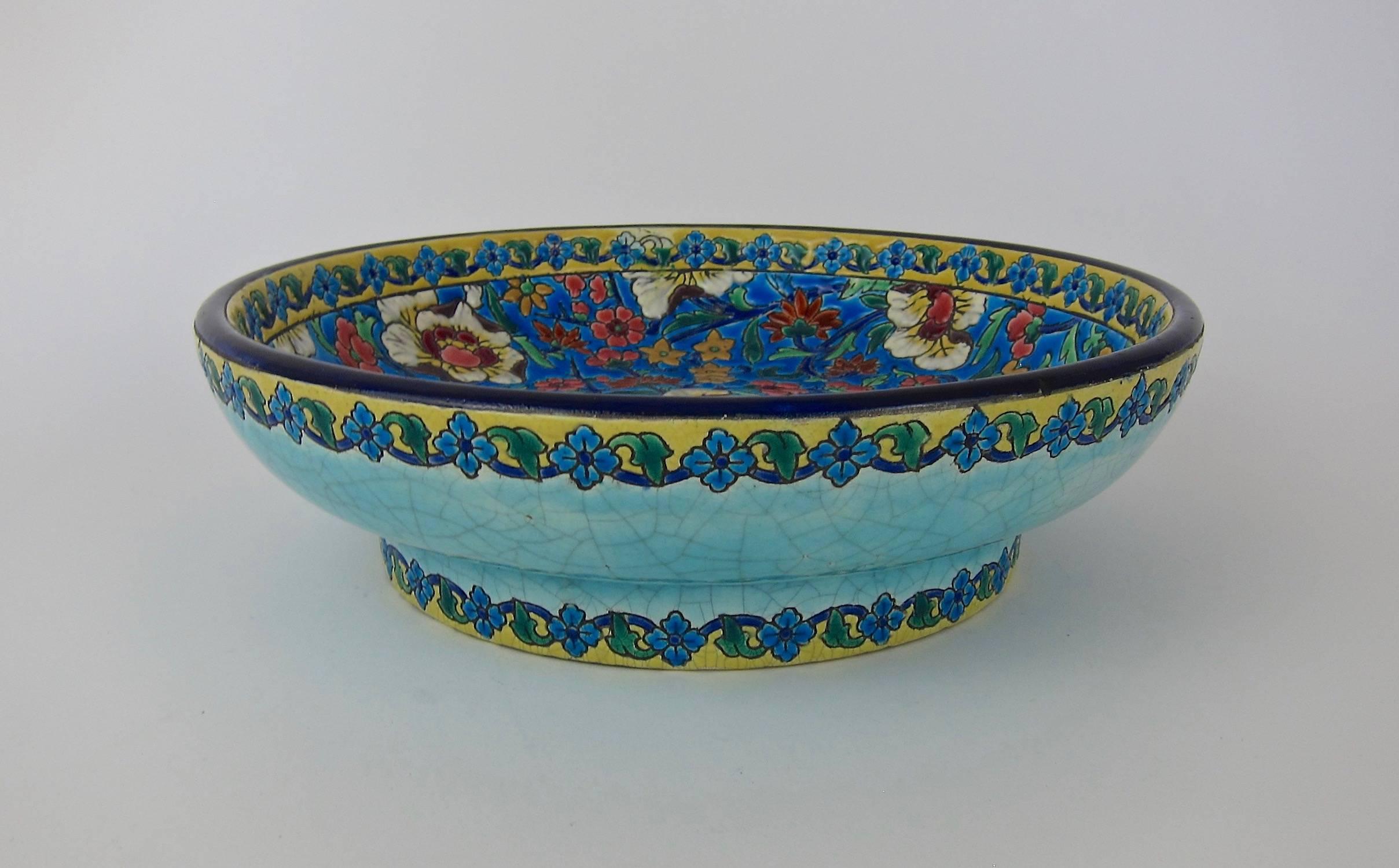 A large Art Deco period faience centerpiece bowl resting on a ring foot, made in France by the Emaux de Longwy art pottery workshop and dating circa 1920s. The earthenware bowl is hand-decorated with Chinoiserie decor and a cloisonné-style enameled