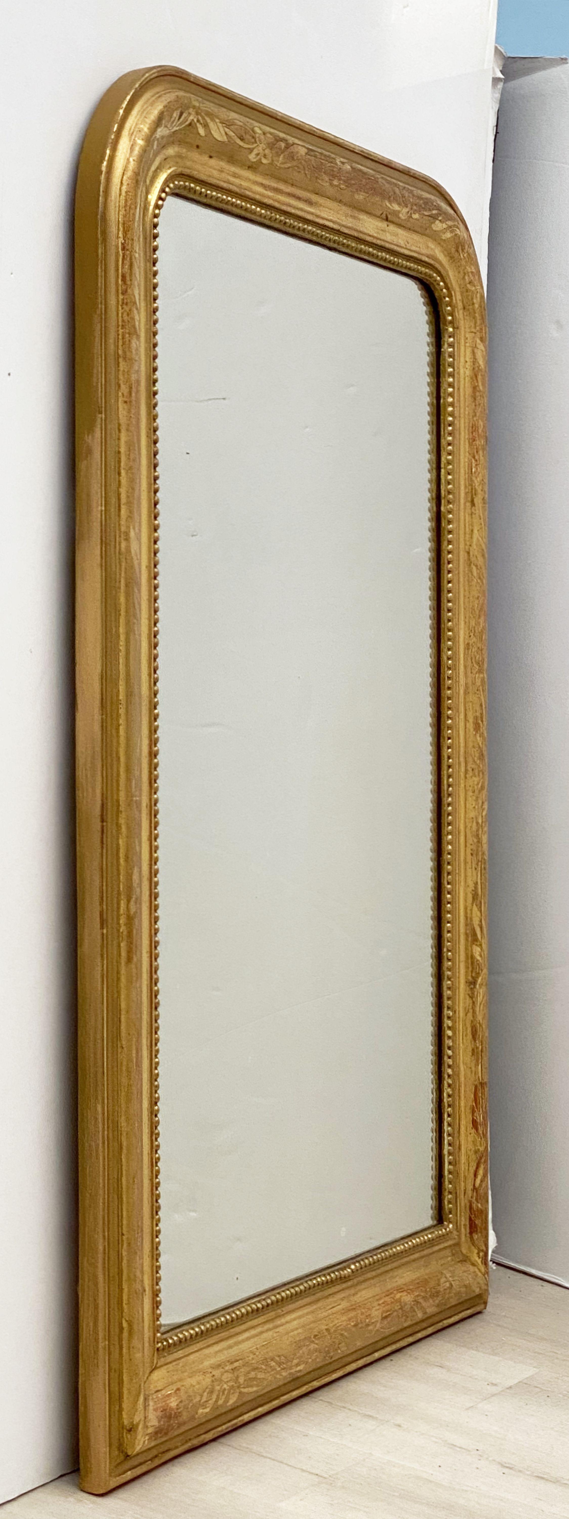 A handsome large Louis Philippe gilt wall mirror from France, featuring a lovely moulded surround and an etched design showing through gold-leaf.

Dimensions: H 42 1/2 inches x W 30 1/2 inches.