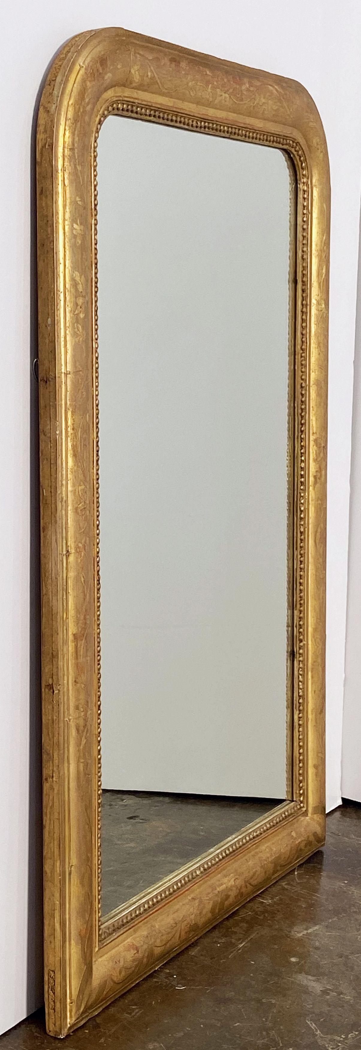 A handsome large Louis Philippe gilt wall mirror featuring a lovely moulded surround and an etched foliate design showing through gold-leaf.

Dimensions: H 38 1/2 inches x W 25 1/8 inches

Other sizes available in this style.
