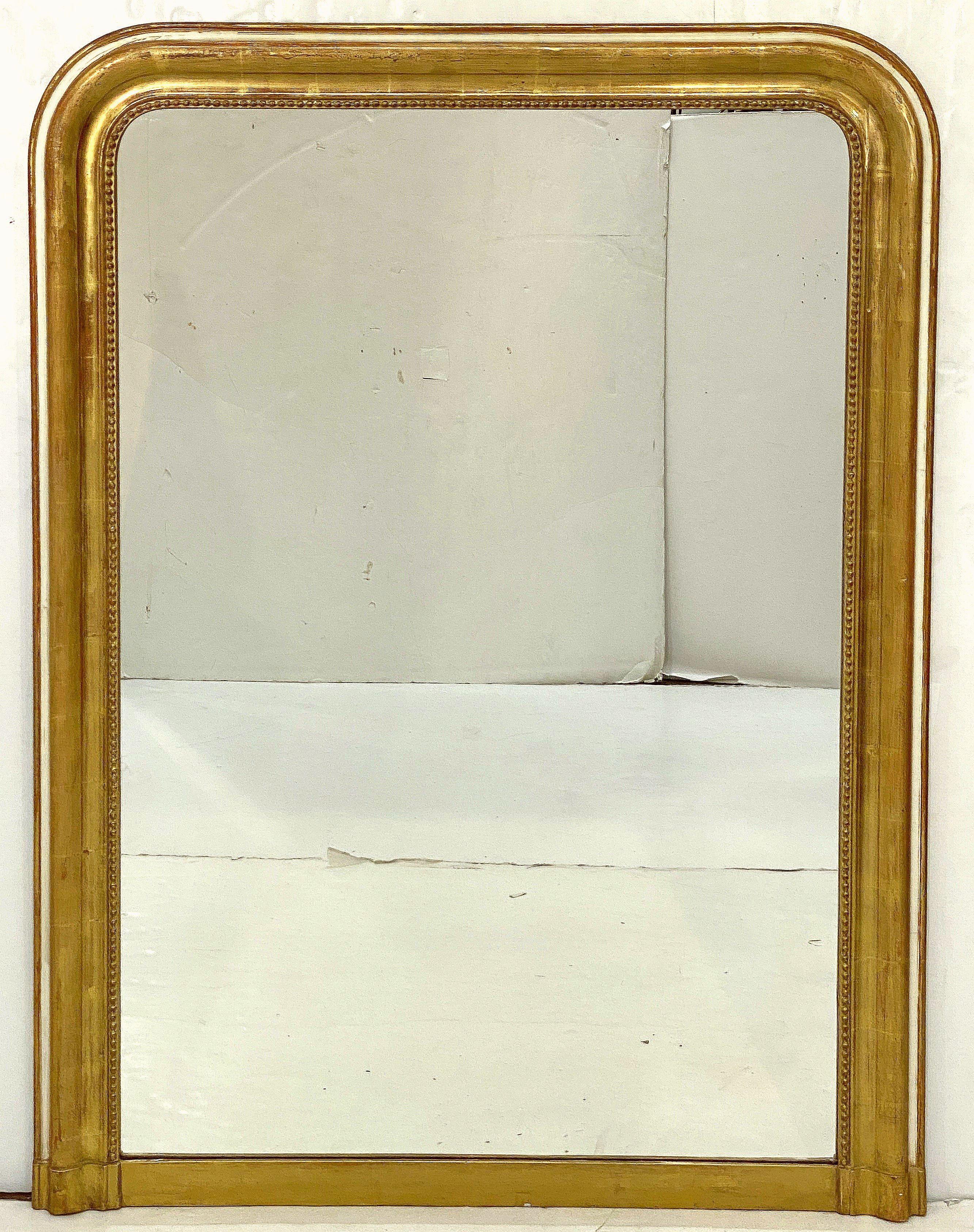 A fine large Louis Philippe arch top wall or overmantle mirror from France, featuring a moulded surround with a beautiful patinated gold-leaf - the outer edge of the frame with a decorative band of natural polished cream gesso creating a gentle