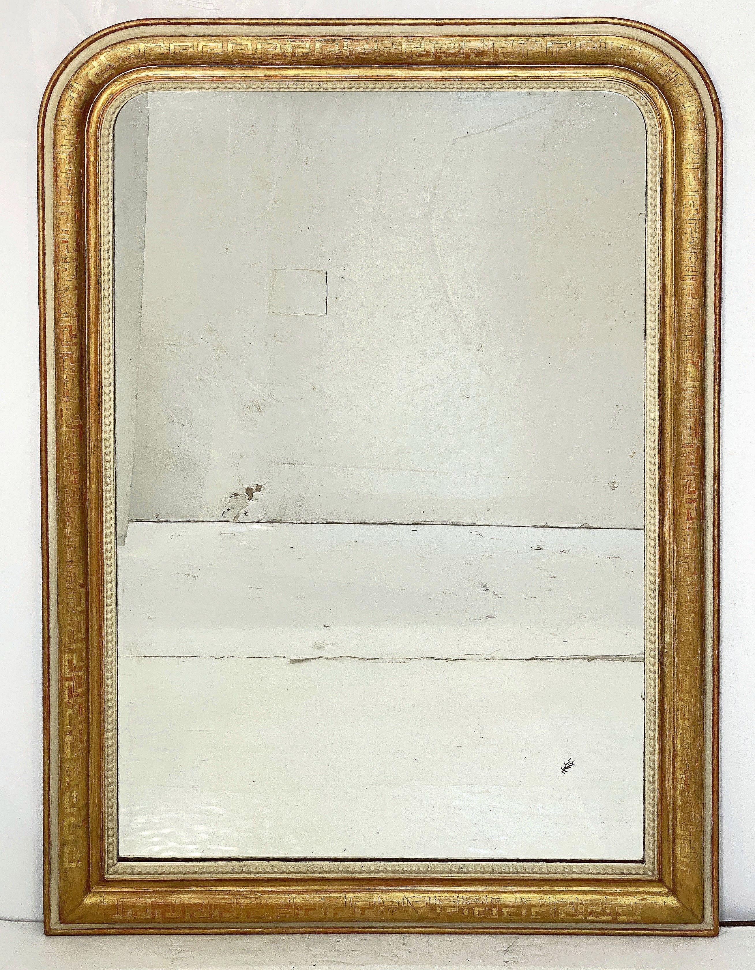 A fine large French arch top wall or overmantle mirror from the Louis Philippe period.

Featuring a moulded surround with a beautiful patinated gold-leaf - the wider scale frame has an outer gilded edge upon a red bole base coat - the outer edge of