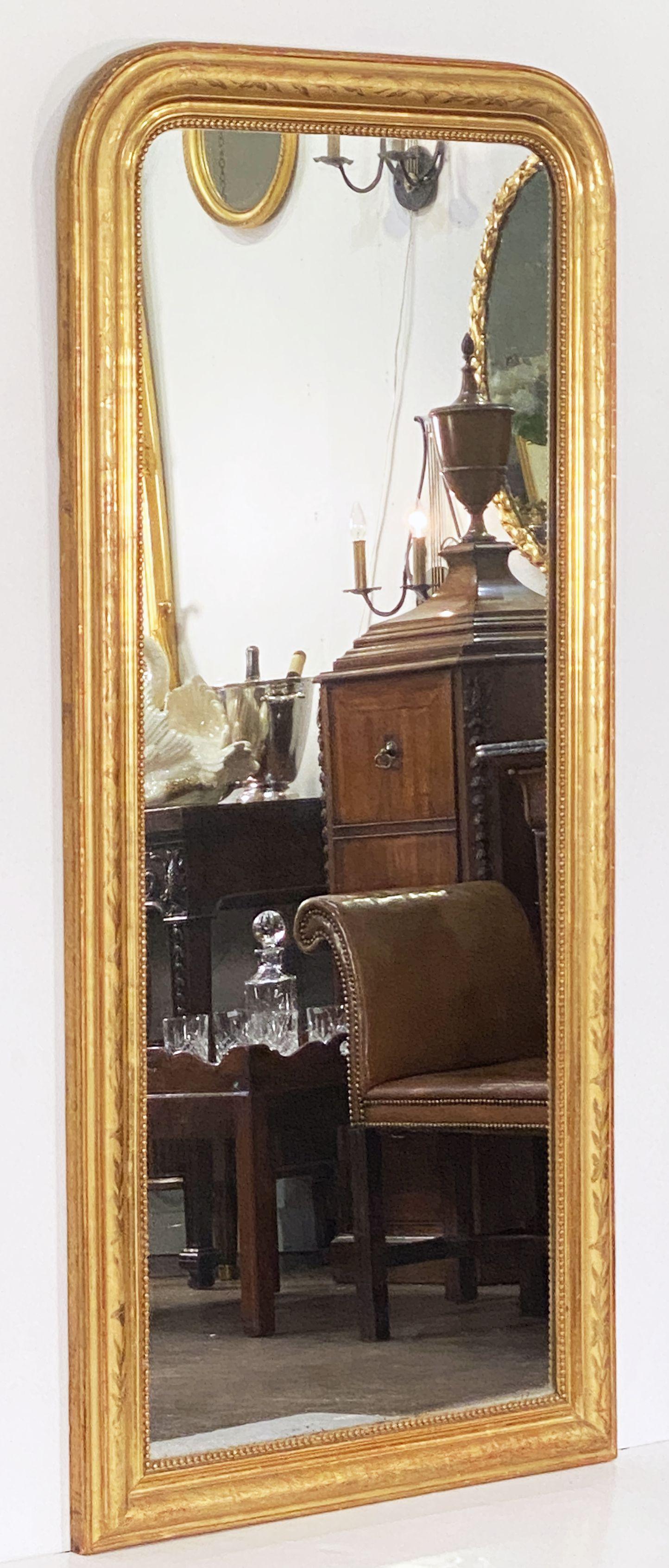 A fine tall Louis Philippe wall or dressing console mirror from France, featuring a moulded surround with a beautiful patinated gold-leaf - the outer border with a narrow rope twist design and, to the inner frame, a border of interlocking flowers