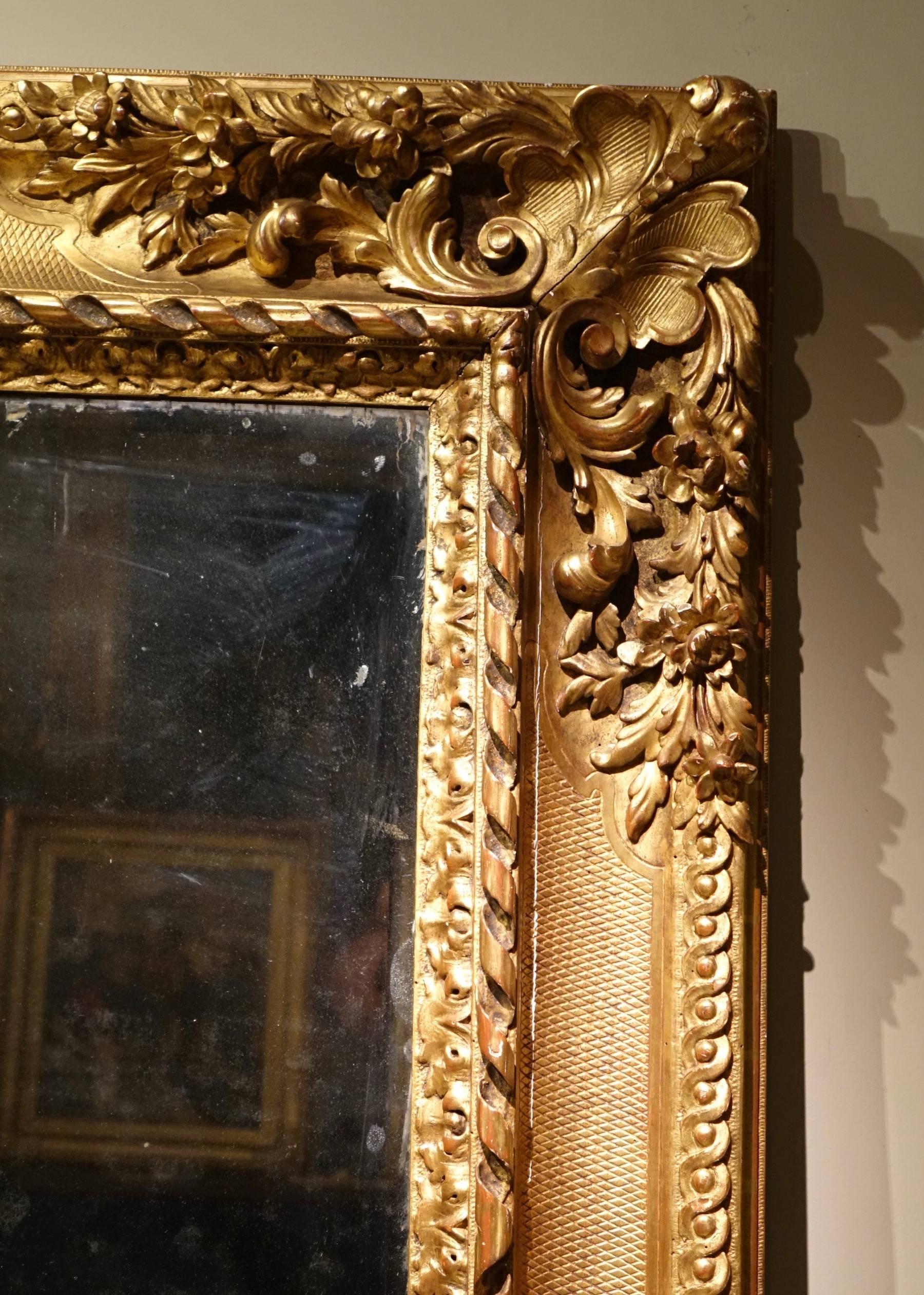 Large Louis XIV style mirror, France  circa 1850
Rectangular mirror richly decorated, with fishnet pattern, Louis XIV style, gilt wood (no stucco elements).
Mercury bevelled central glass.
Original parquetry wood back.
The mirror can be displayed