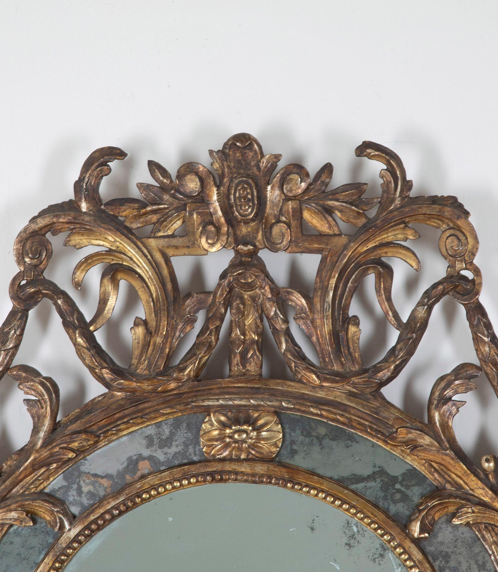 Un bellissimo specchio d'epoca Luigi XV di dimensioni eccezionali e in splendide condizioni originali. 
Di dimensioni impressionanti, il piatto diviso ad arco all'interno di una cornice in legno dorato finemente intagliato e riccamente ornato con