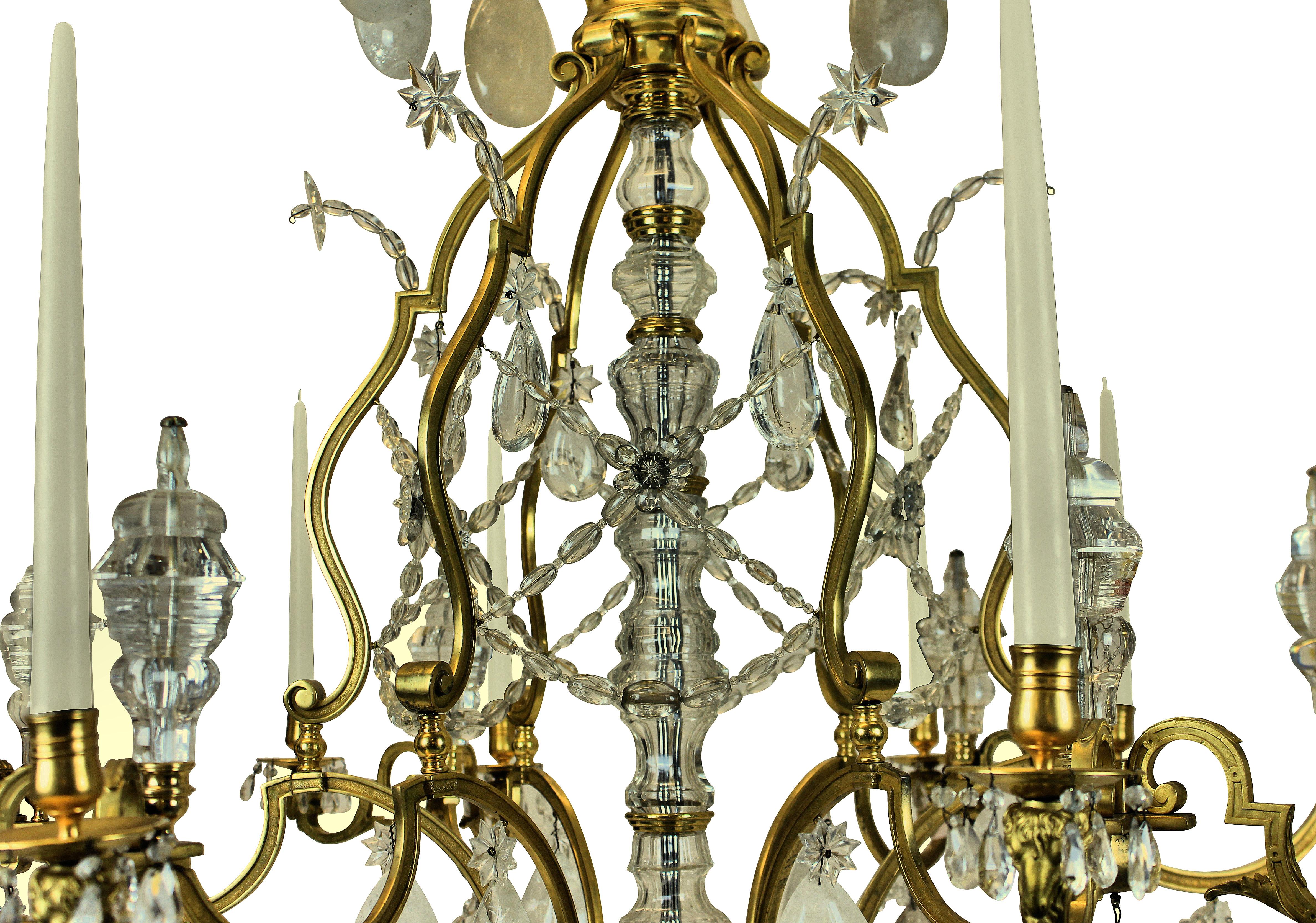 A large Louis XV style chandelier of the highest quality, with mercury gilded and burnished bronze and hung with rock crystal. With ram's head decoration to each arm, of which there are twelve in total, with beads, spires and pendant drops. Can be