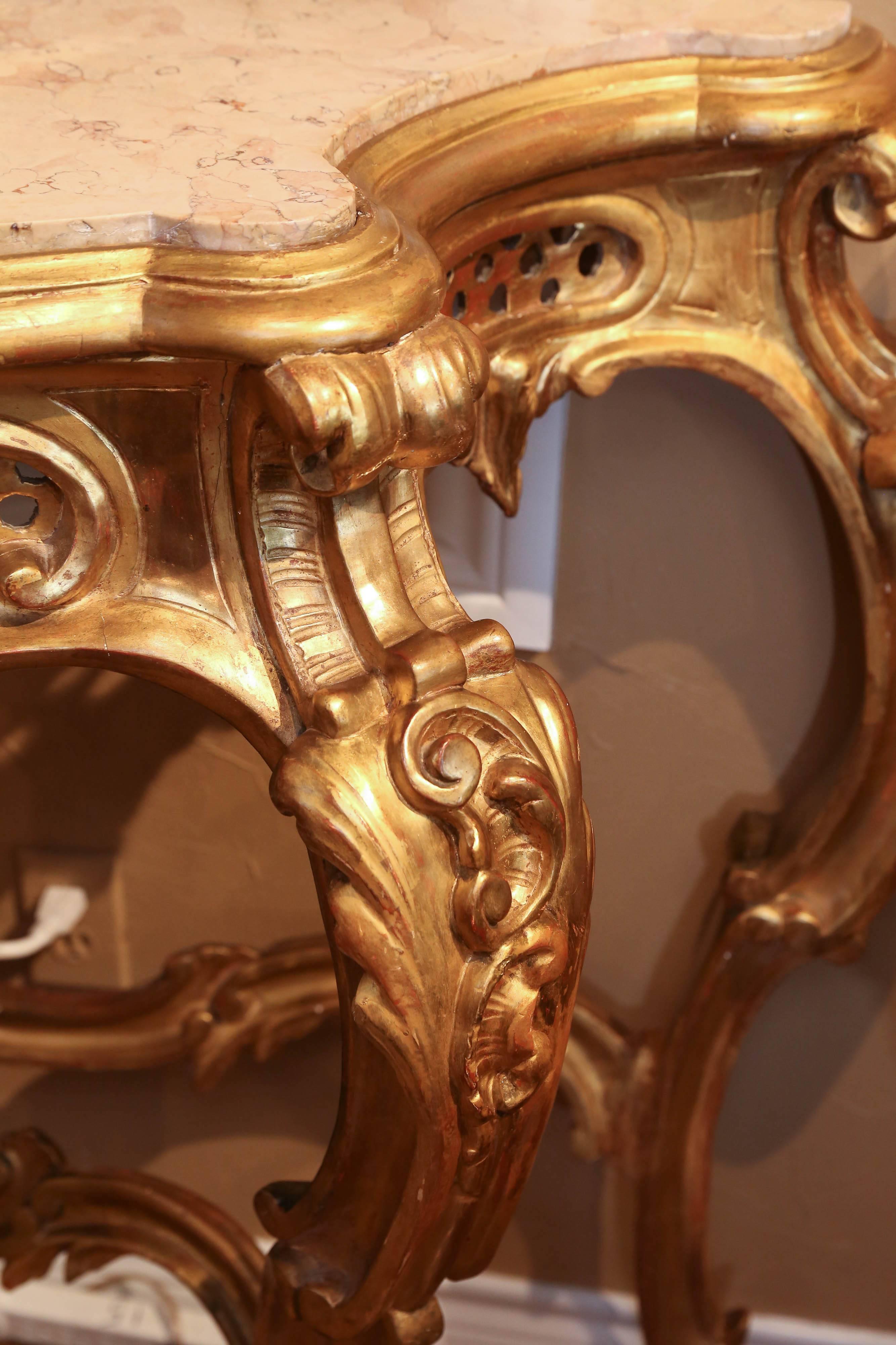 Monumental Louis XV console table, heavily carved and a lovely pierced apron,
Rising on cabriole kegs with stretcher, ending in scroll feet. Beautiful
Gilt patina, gilt gesso over carved wood frame.