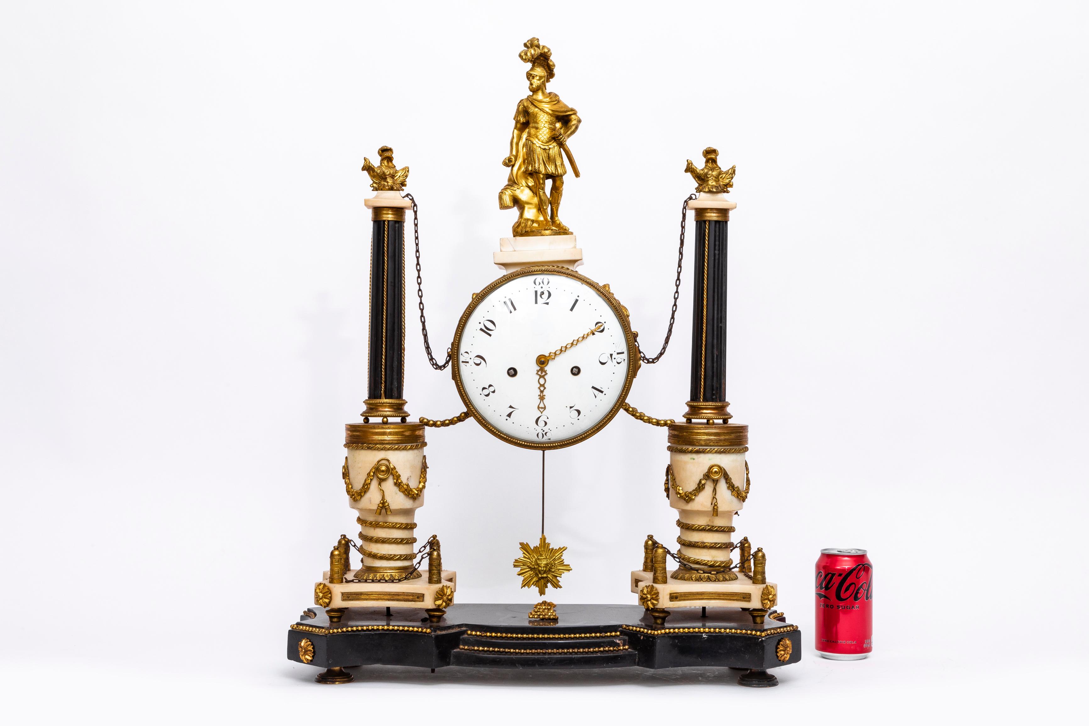 A Magnificent and Large Louis XVI Period (18th Century) French portico clock, with a double marble column mount and adorned with gilded bronze chains. The pendulum takes the form of a sun.   During the 18th century, French furniture production took
