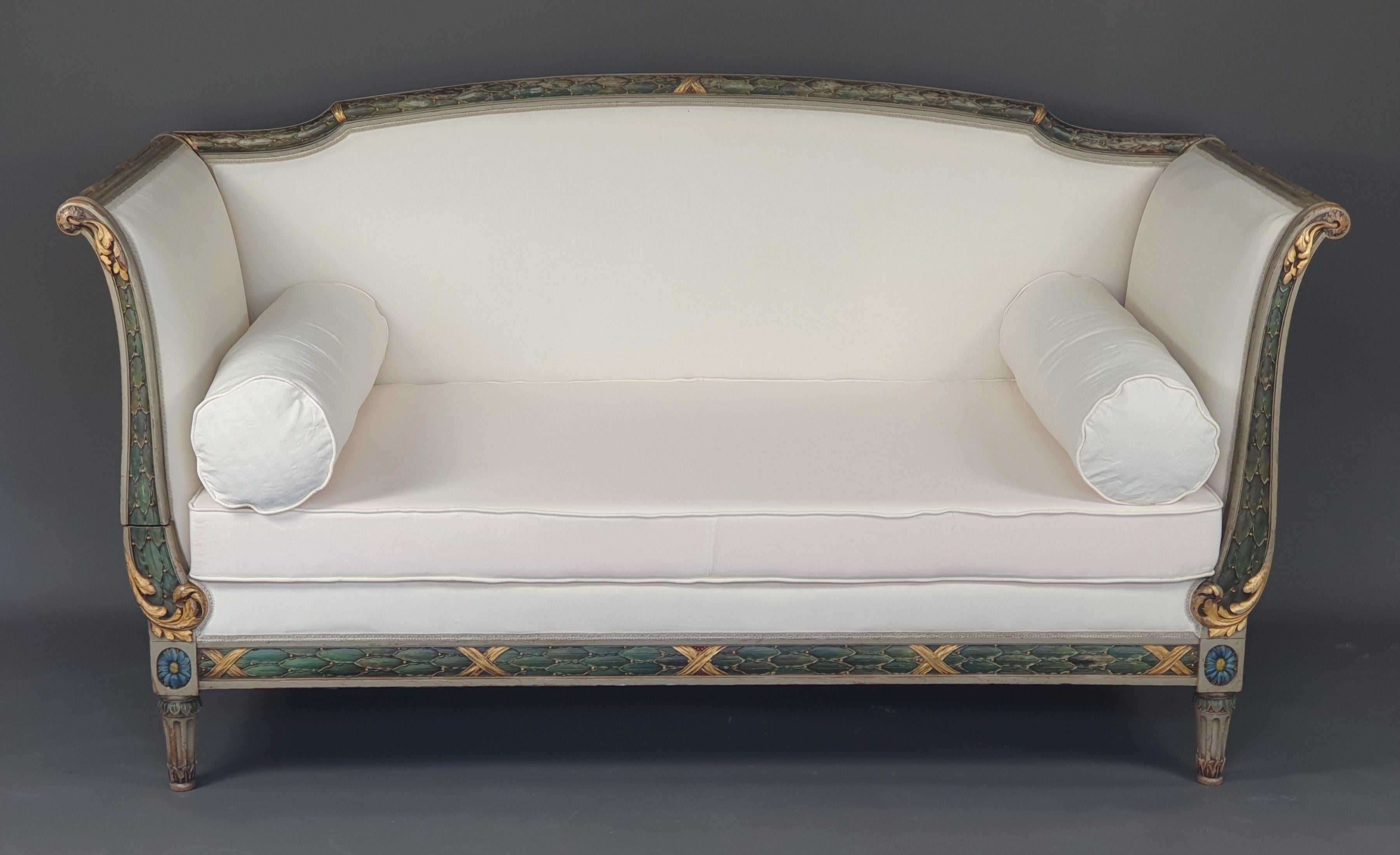 Magnificent Louis XVI sofa in the style of the ottomans in gray lacquered wood and green, blue and gold rechampi with rich carved decoration of scrolls, wrapped foliage, resting on four fluted legs, the connecting dice in the shape of