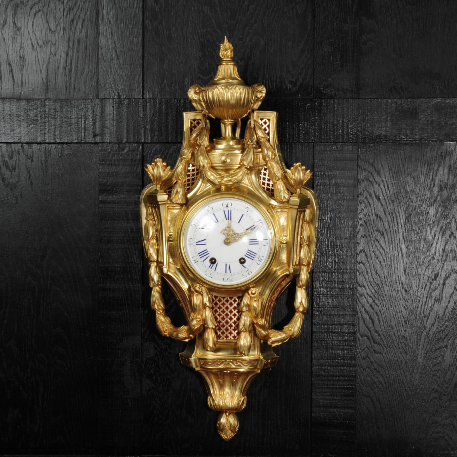 A fine and substantial original antique French cartel wall clock. Beautifully modelled in the Louis XVI style, made of finely finished and gilded bronze. The neoclassical baluster shaped case surmounted by an leaf-wrapped vase finial with ram’s mask