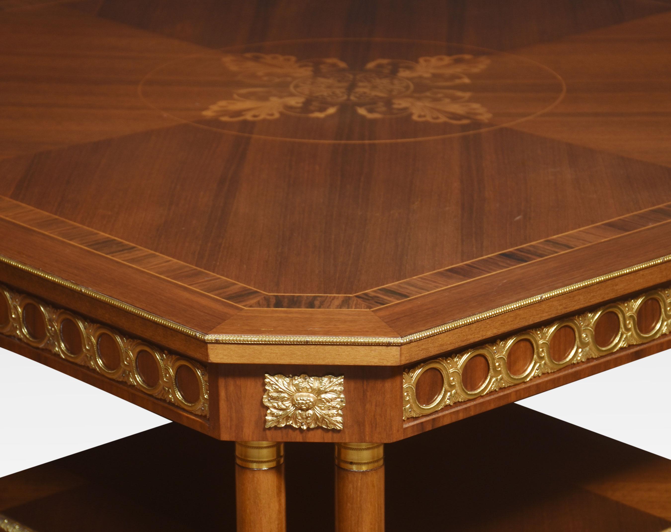 Très grande table basse de style Louis XVI, le plateau avec une marqueterie centrale entourée d'un décor d'anthemion, avec des coins inclinés. Le gel est décoré de montures en métal doré. Le tout repose sur des pieds en forme de colonne et sur une
