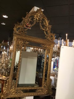 Large Louis XVI-Style Giltwood mirror With mask of Minerva, 19 th c.