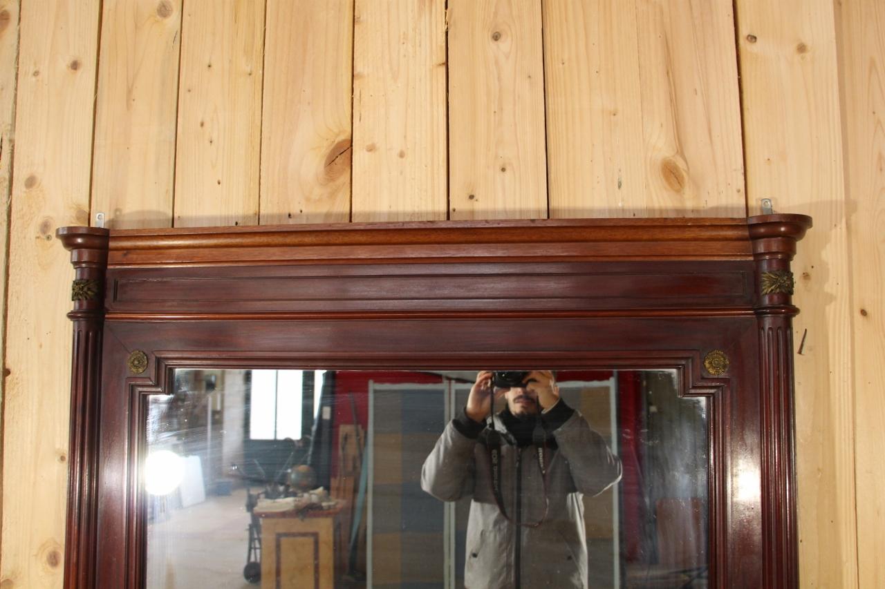 Large Louis XVI style mirror in solid, made at the end of the 19th century. Decorated with bronze on the upper part, in good condition.