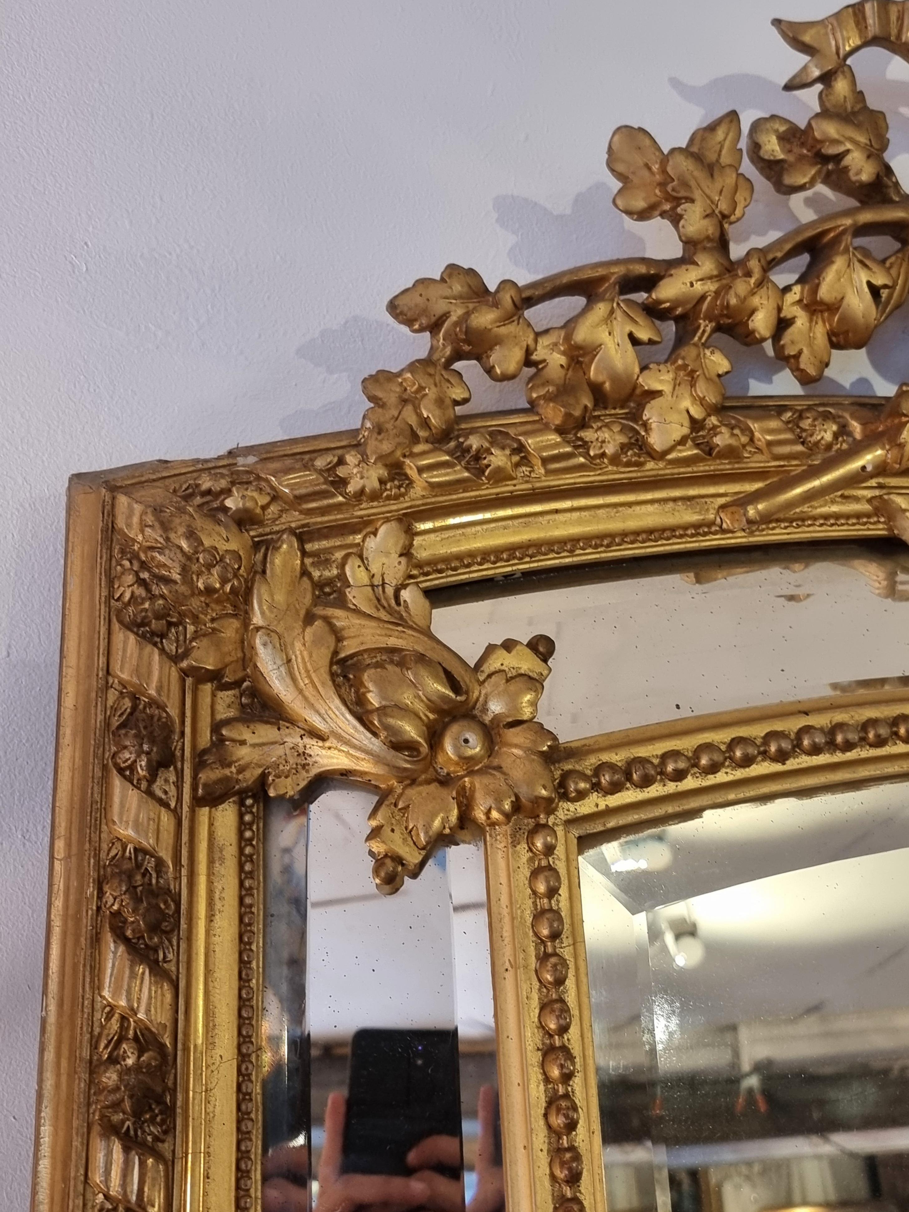 Superb Louis XVI glazing beads mirror from the end of the 18th century. High-quality workmanship with all the mirrors bevelled. The pediment is decorated with dense floral interlacing placed in a wicker basket whose handle is also visible. The